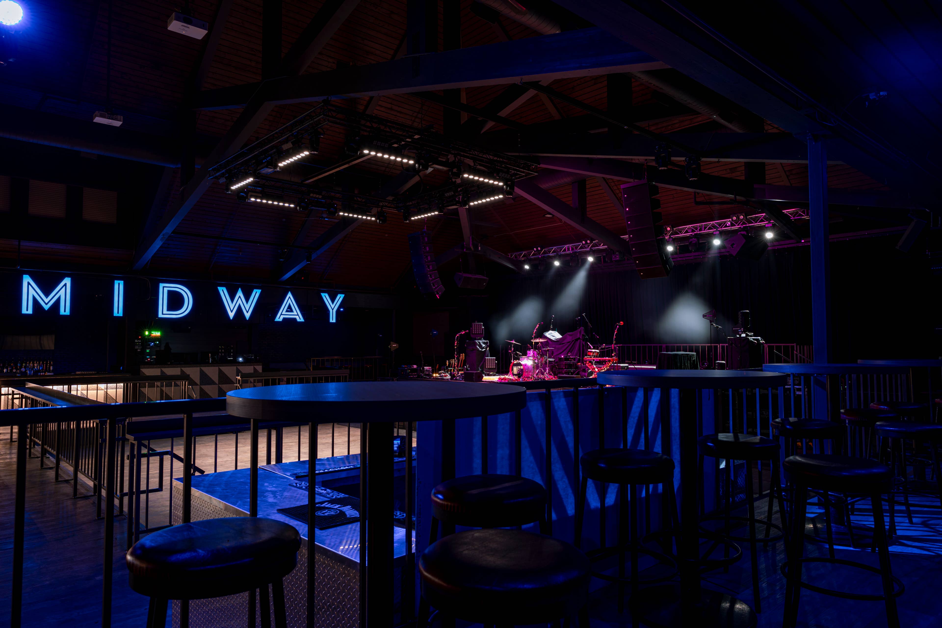 view of the empty  midway music hall venue including their light up marquee sign and table seating