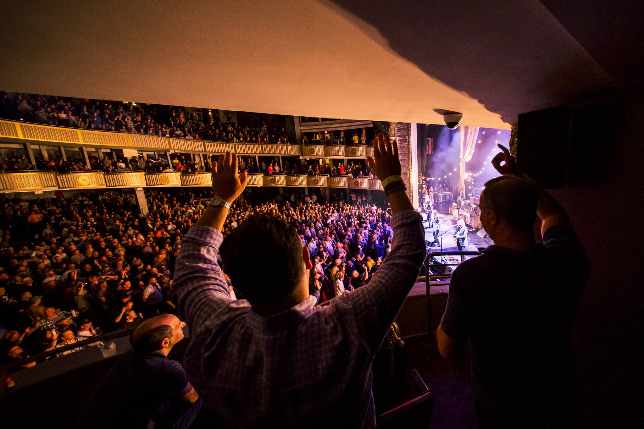 A guest with their hands up in the air staring at the stage during a show at The Met Philly