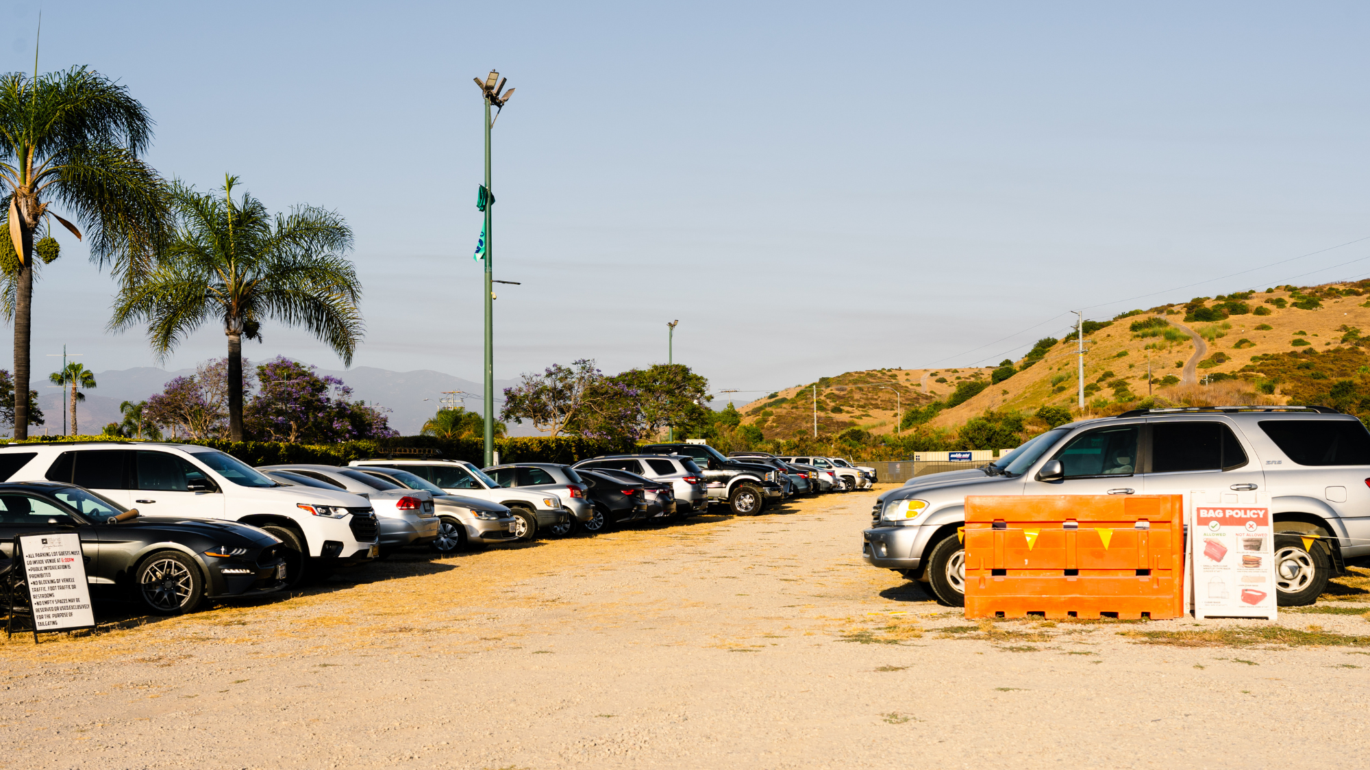 Cars parked in a gravel parking lot.