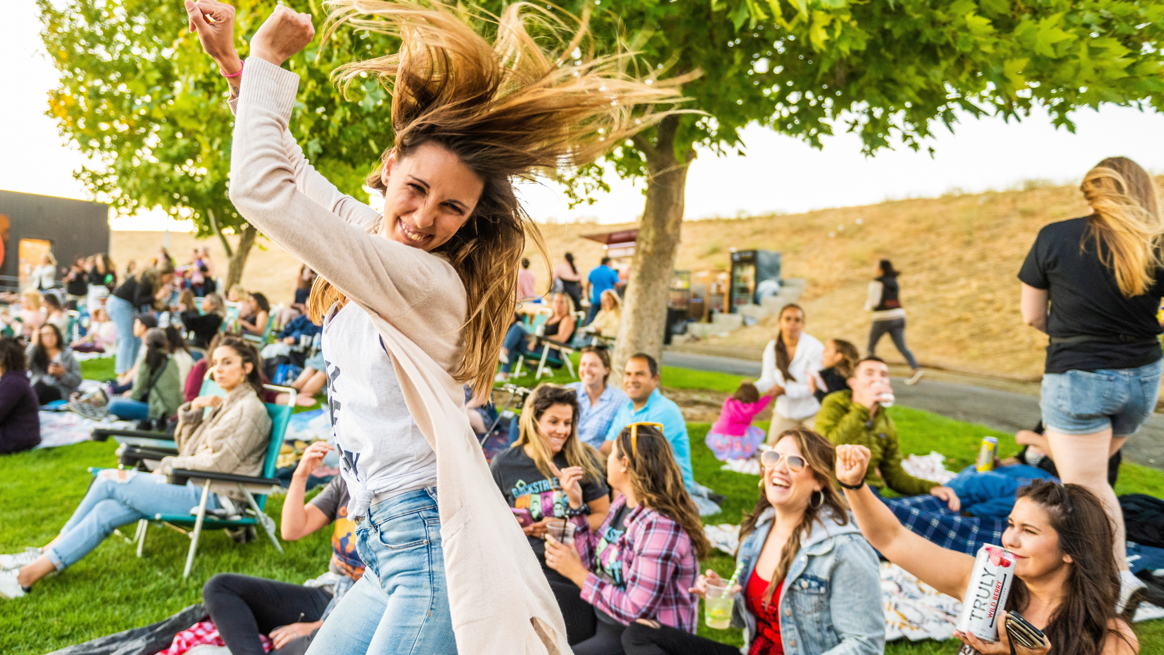 A woman dancing on the lawn at Toyota Pavilion at Concord with her hair flying around in the air