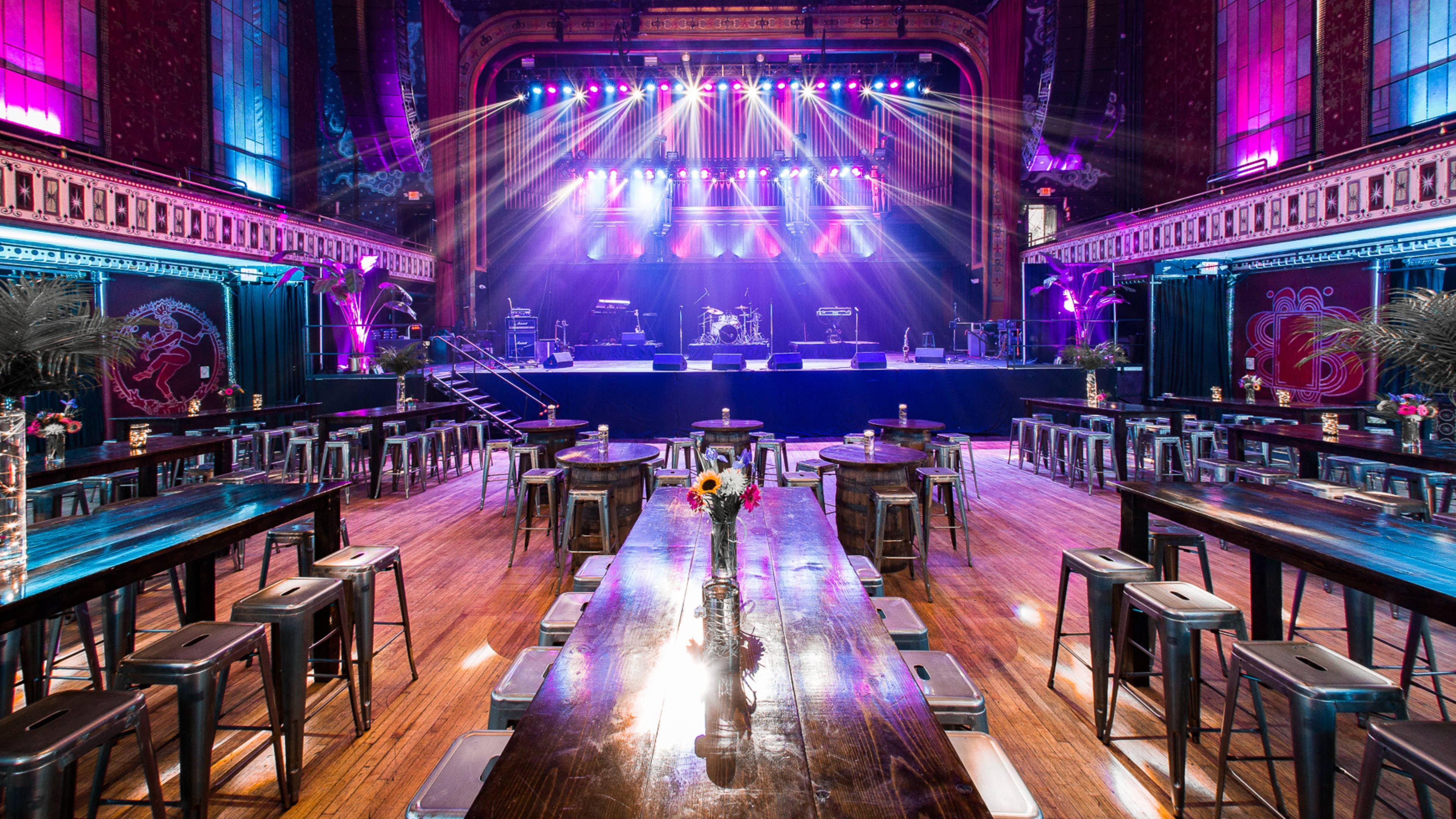 The main floor of the Tabernacle decorated for a private event with flowers, tables, seating, and the stage with lights