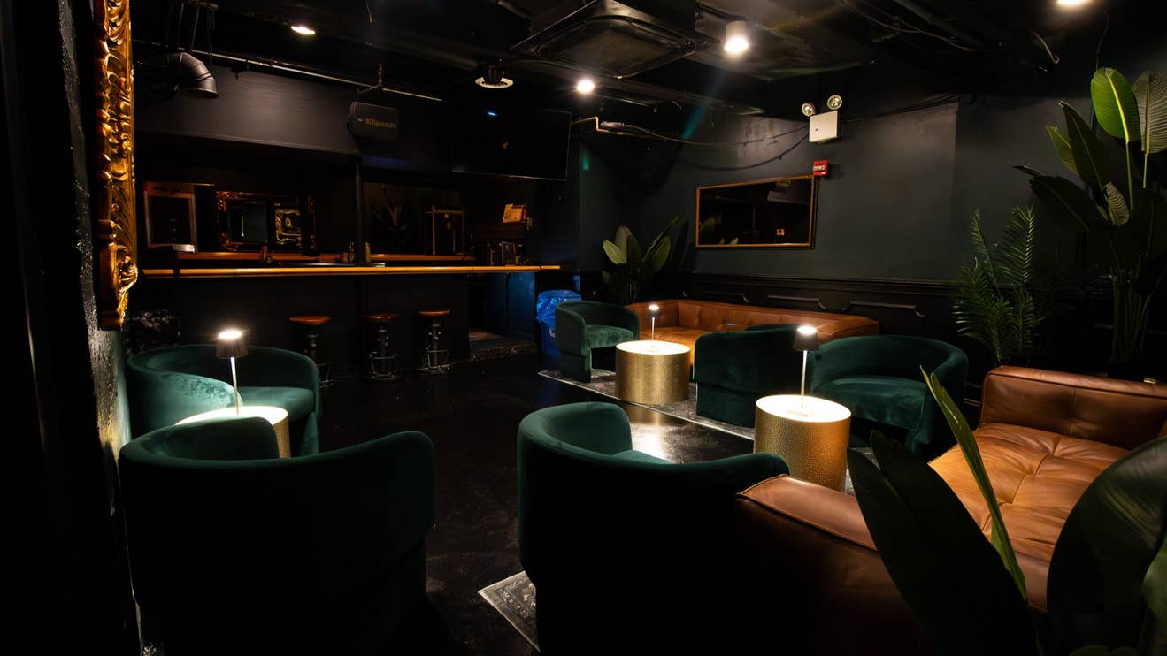 A dimly lit lounge with couches and a bar