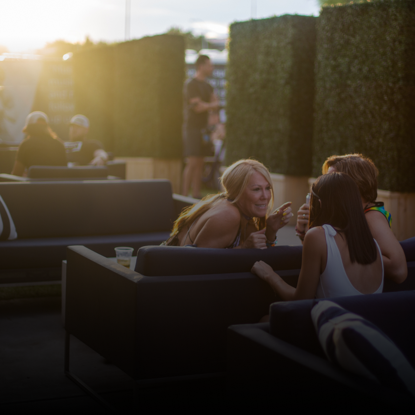 3 friends sitting and talking with drinks in their hand 