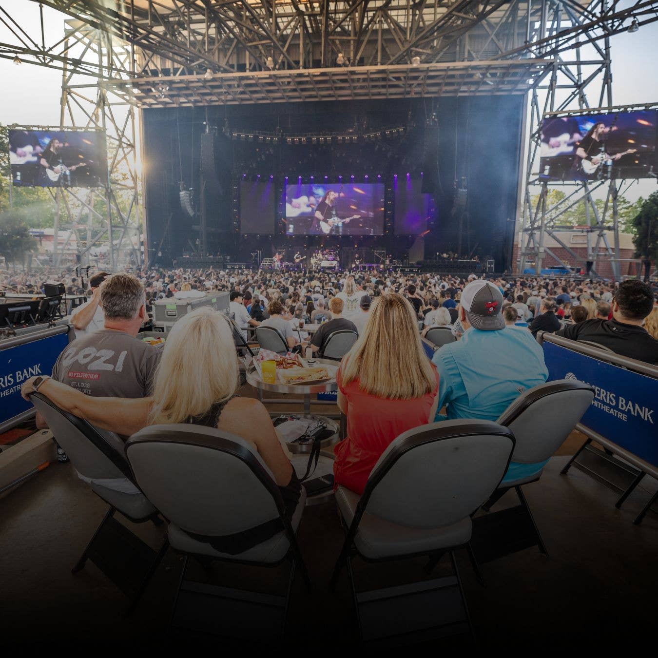 Four fans watching a show from box seats