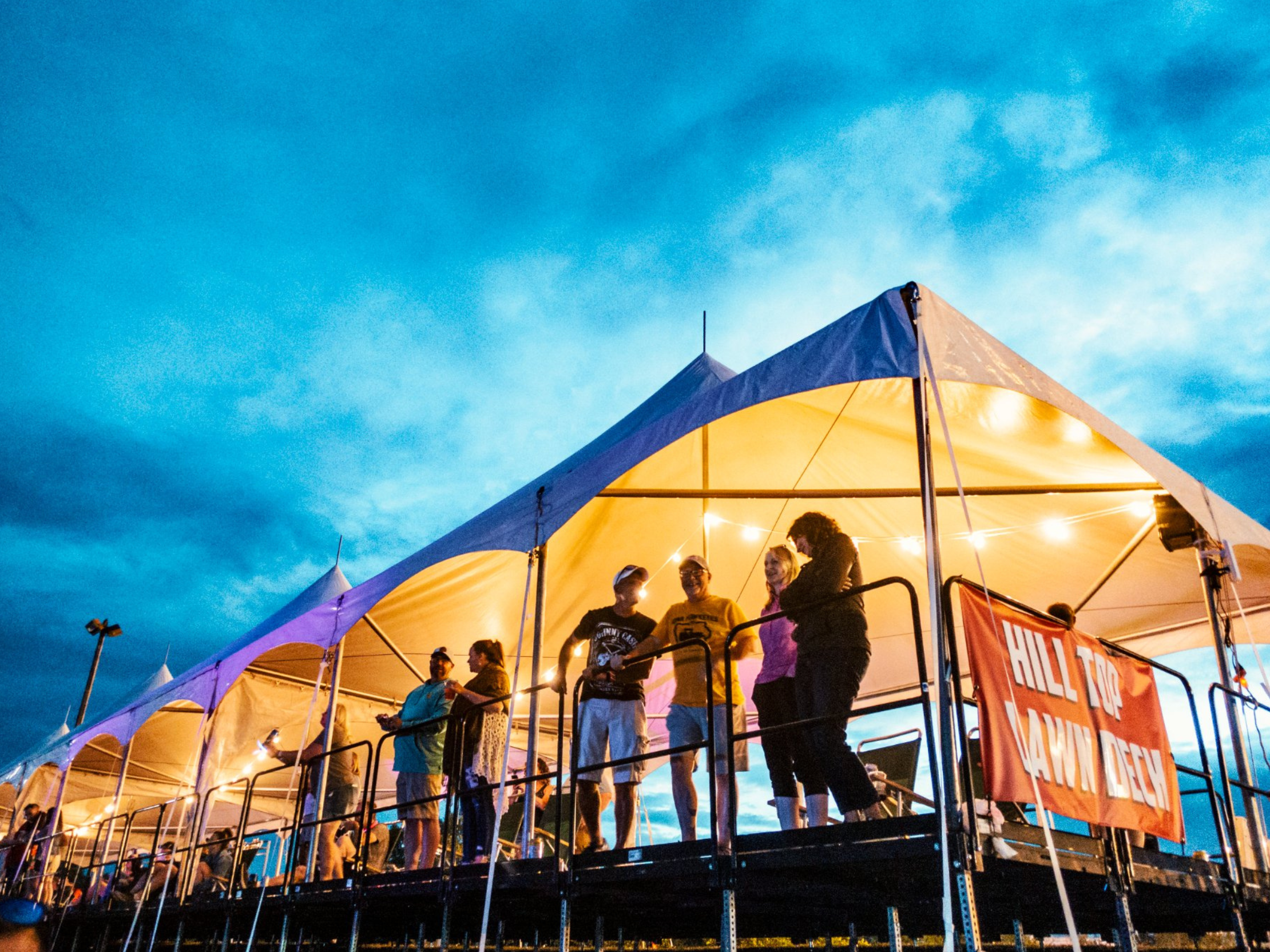A group of people standing under a tent. 