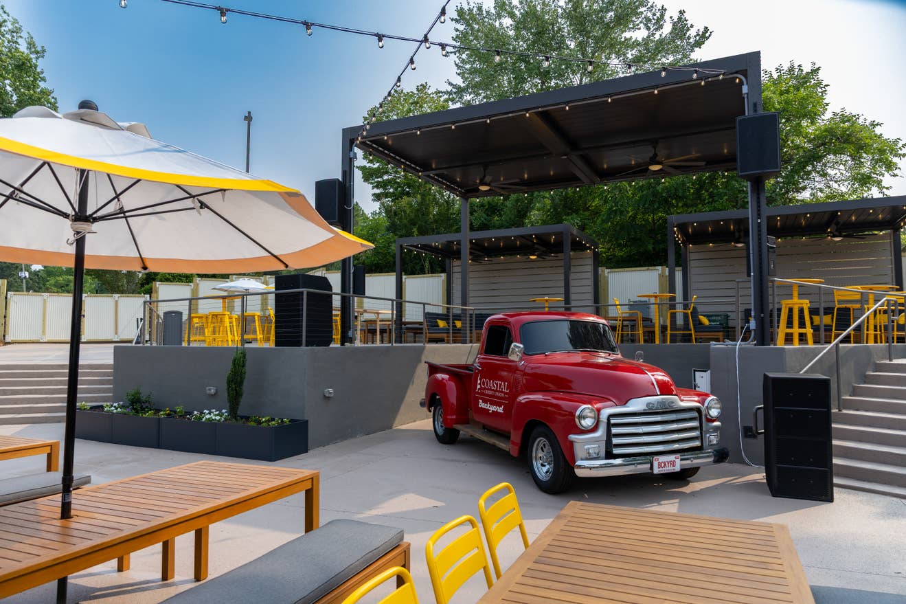 A picture of a red truck and yellow tables and chairs.