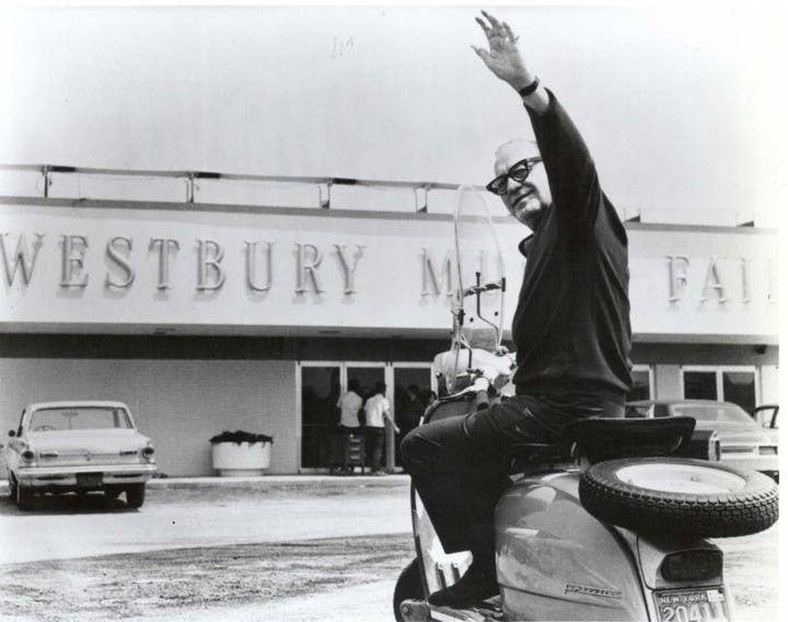 1966 - Jack Benny on a Vespa waving at the camera with the Westbury signage in the background