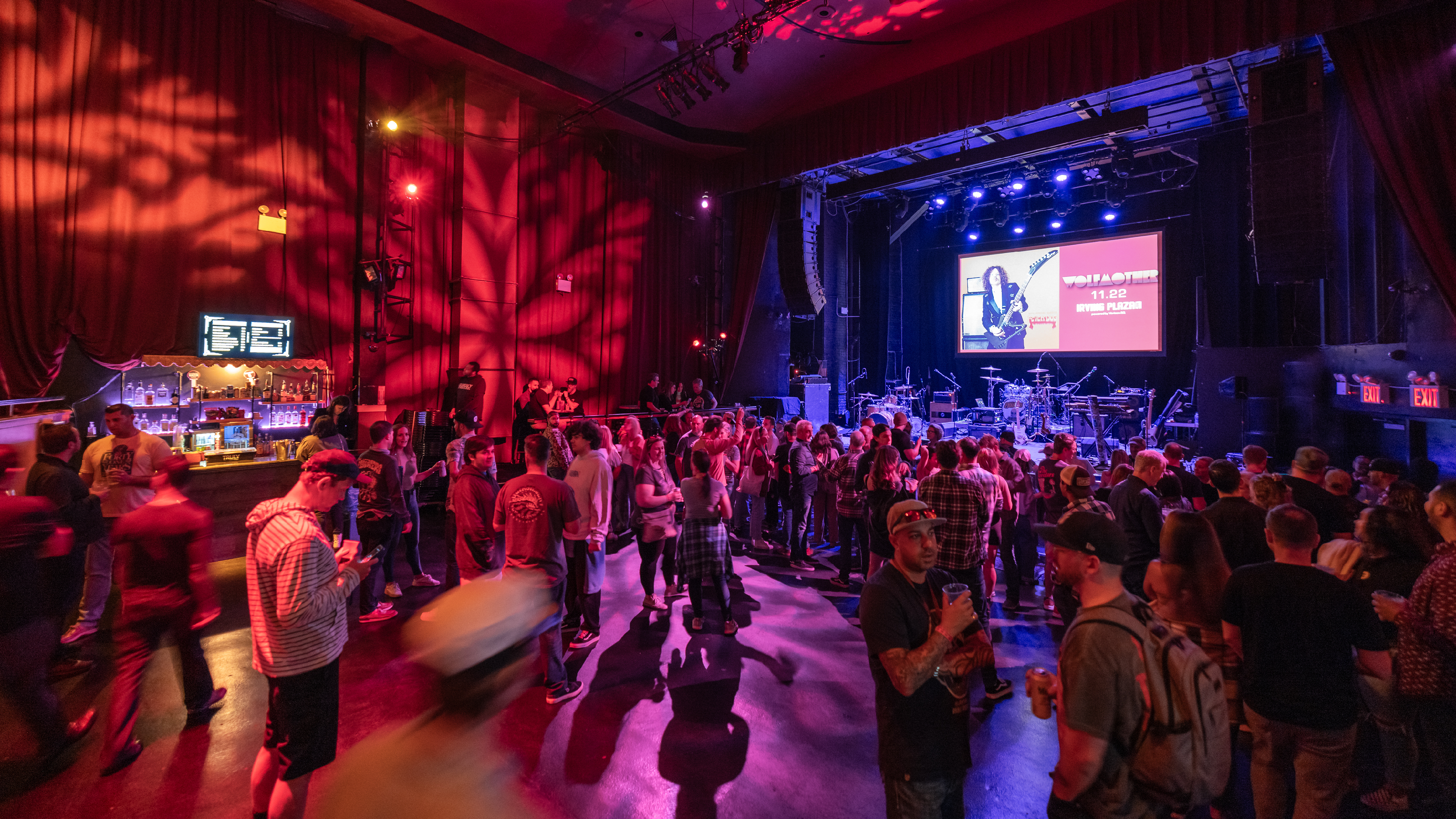 People chatting and drinking on the main floor while they wait for a concert to start a Gramercy Theatre. 