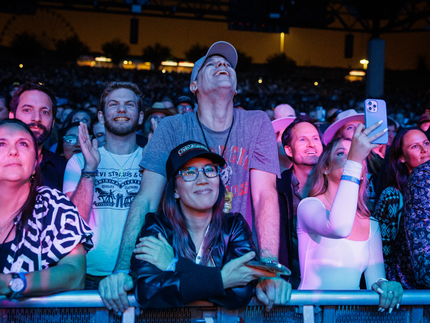 A couple standing at the barricade looking at the stage.