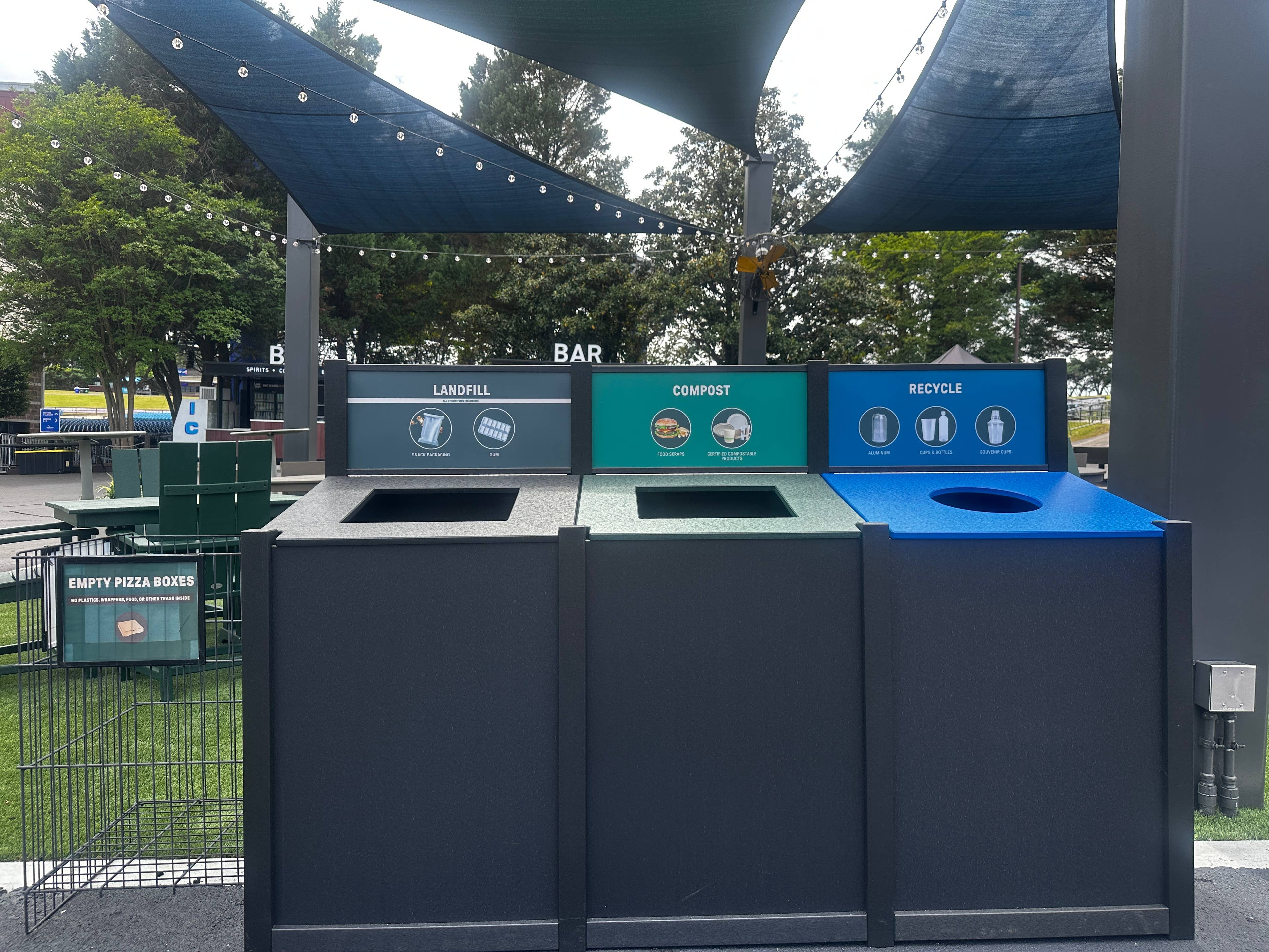 A photo of the trash cans at Truliant Amphitheater showing landfill, compost and recycle sections.
