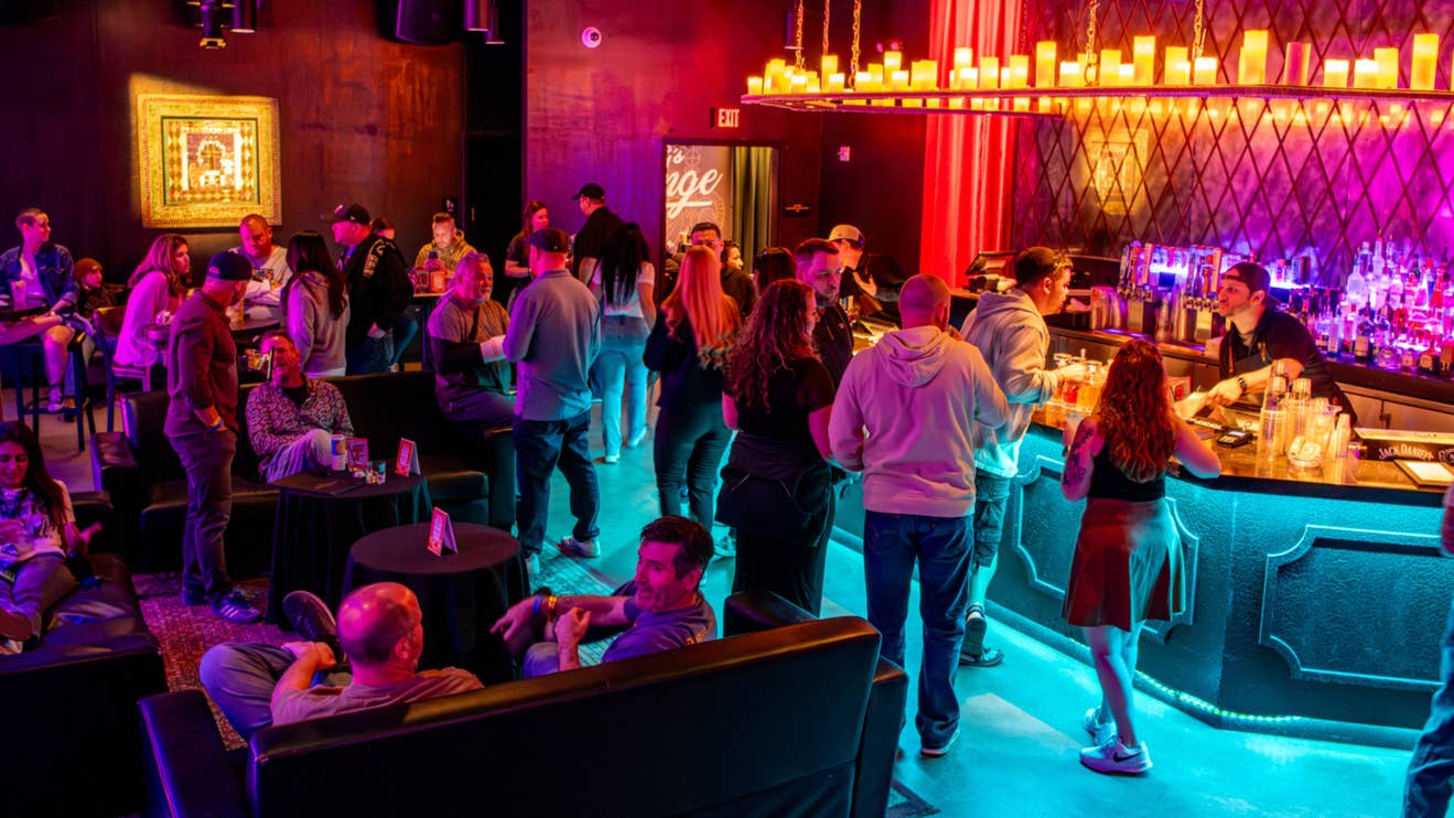People standing and sitting around at a lounge.