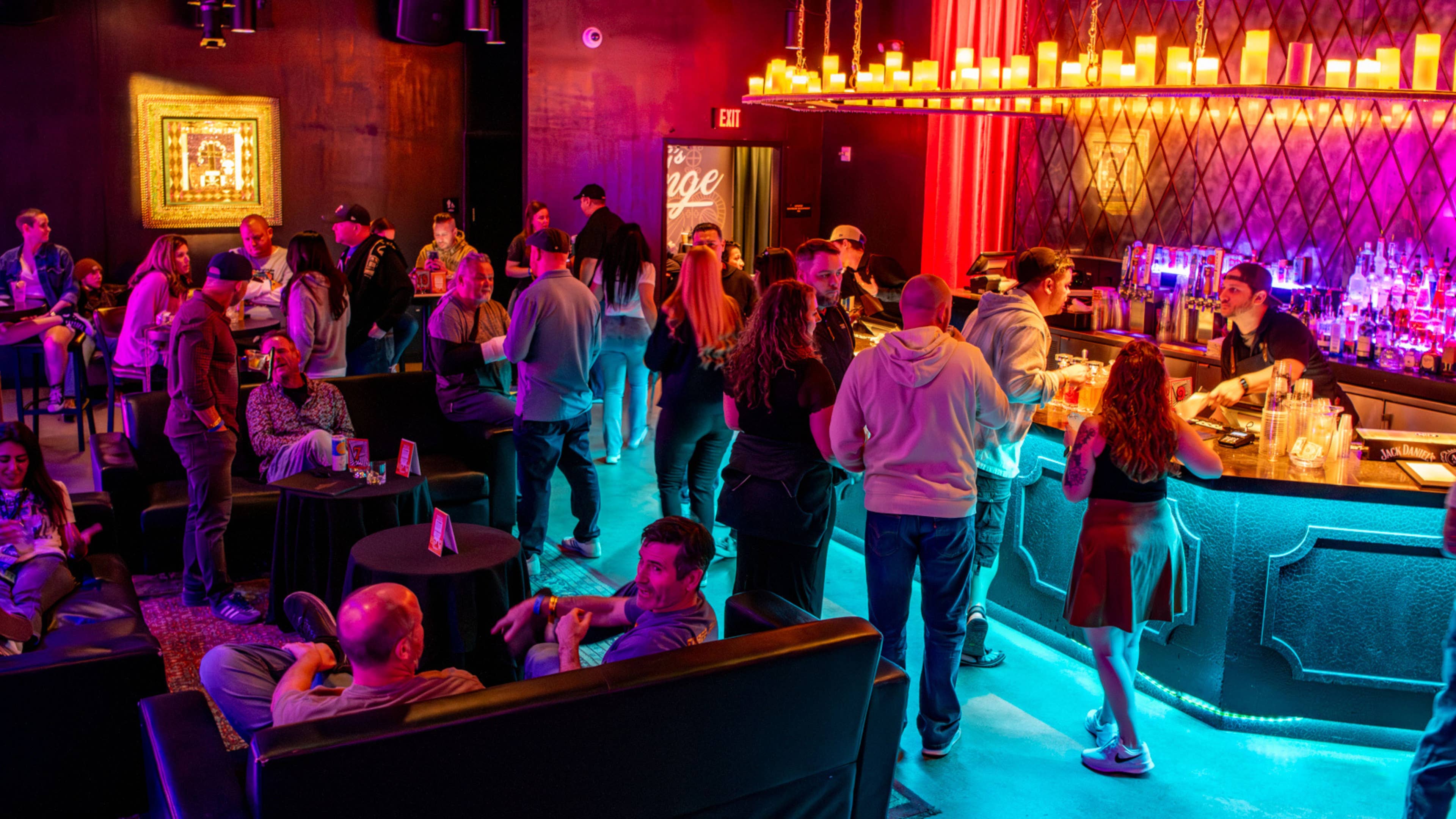 People standing and sitting around at a lounge.
