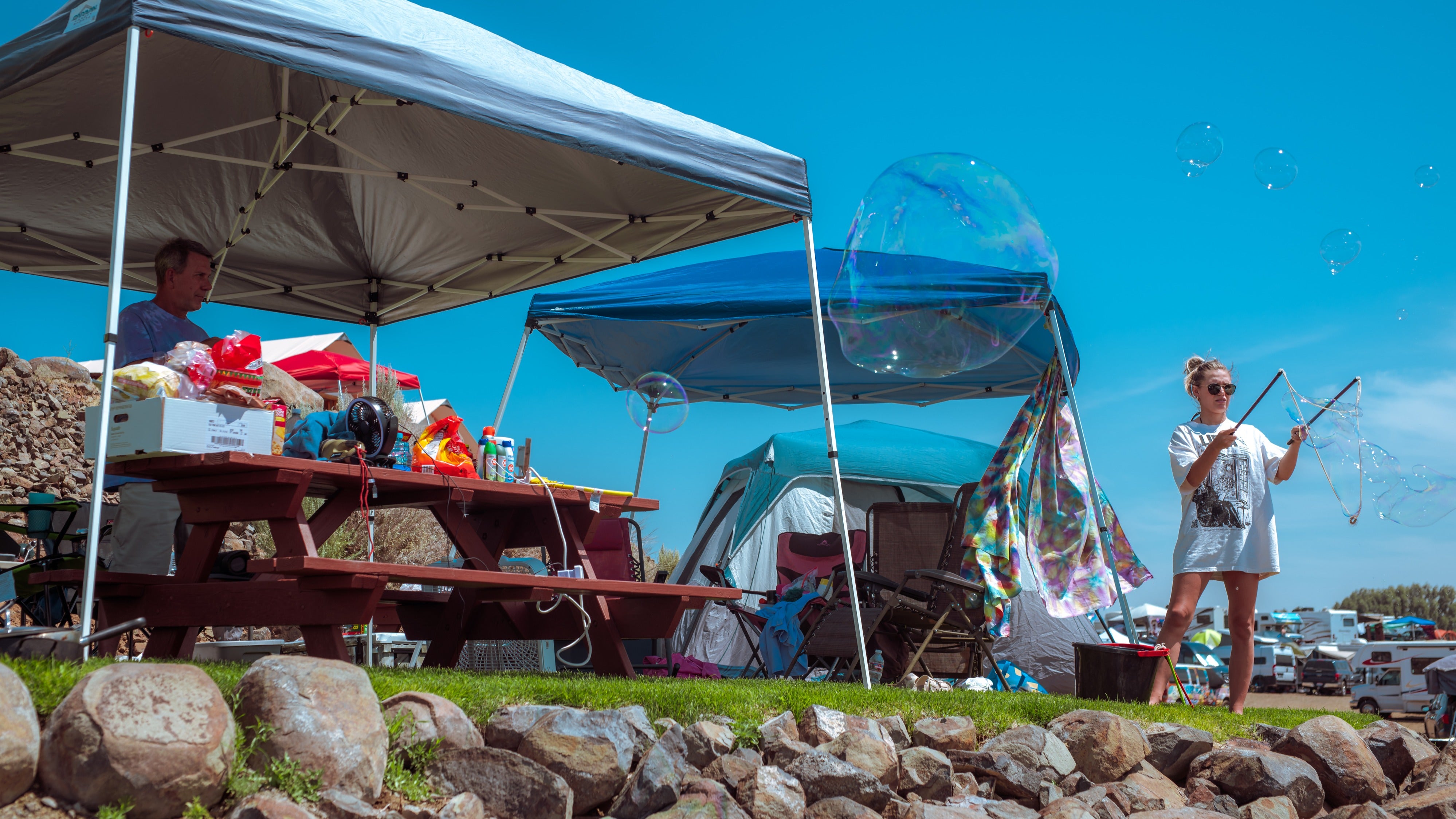 Canopy tents set up with a picnic table beneath the tent
