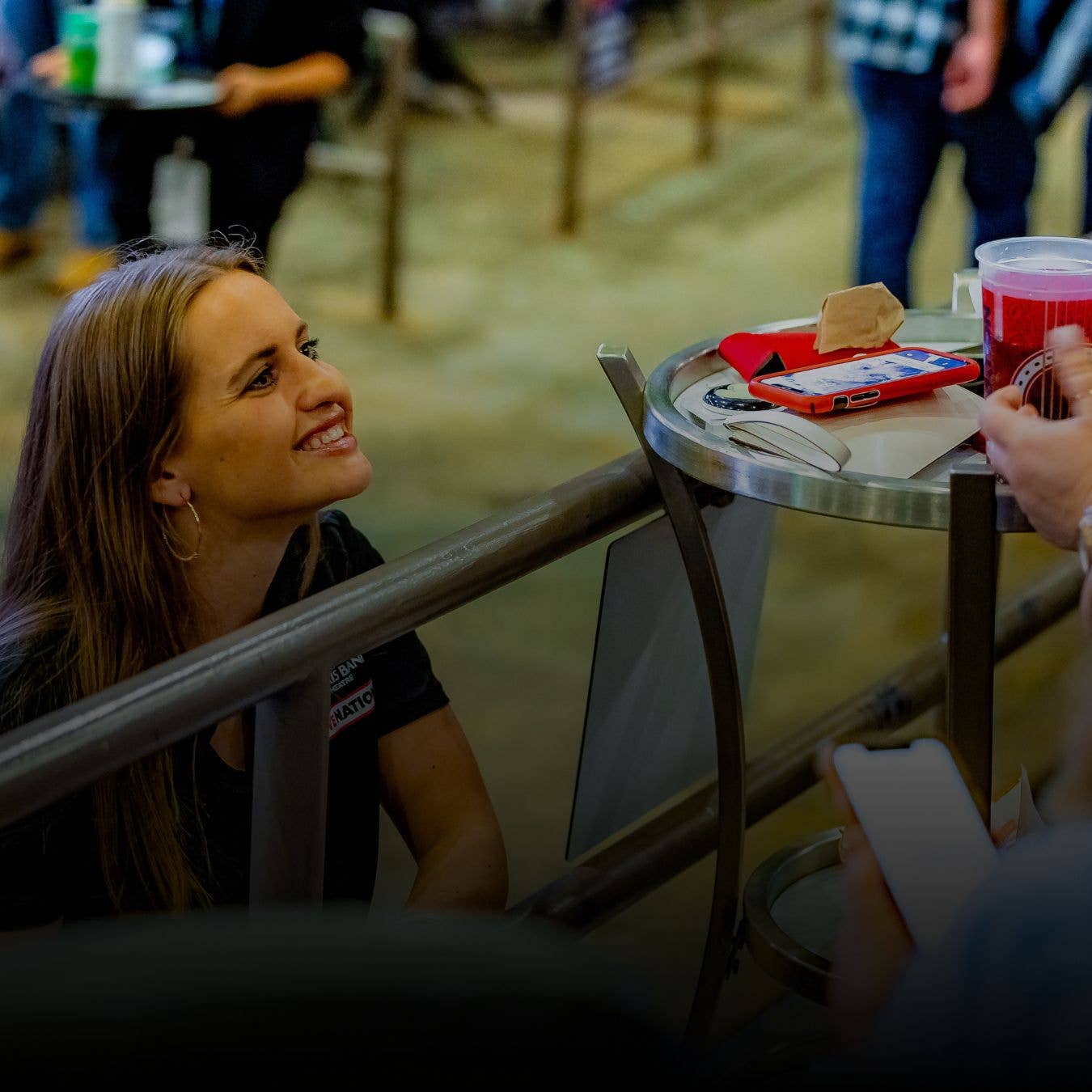 A photo of a server talking to customers in a box seat