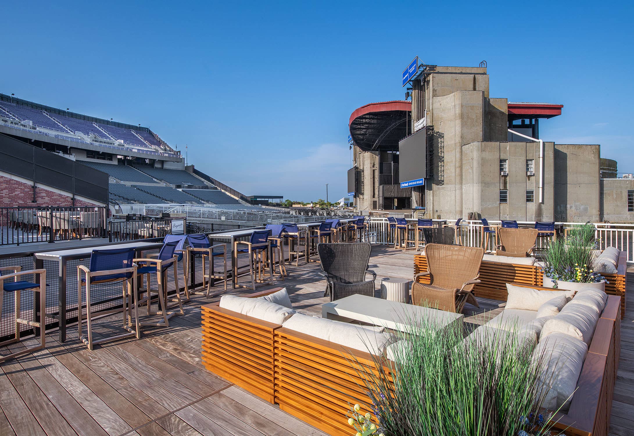 An exterior space with couches and high top seating facing the side of the amphitheater