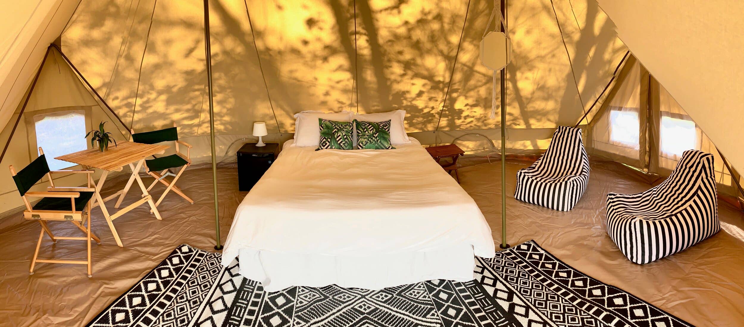 20' wide & 10' tall bell tent
A bistro table, chairs, side table, rug and mattress and frame with a linen sheet set