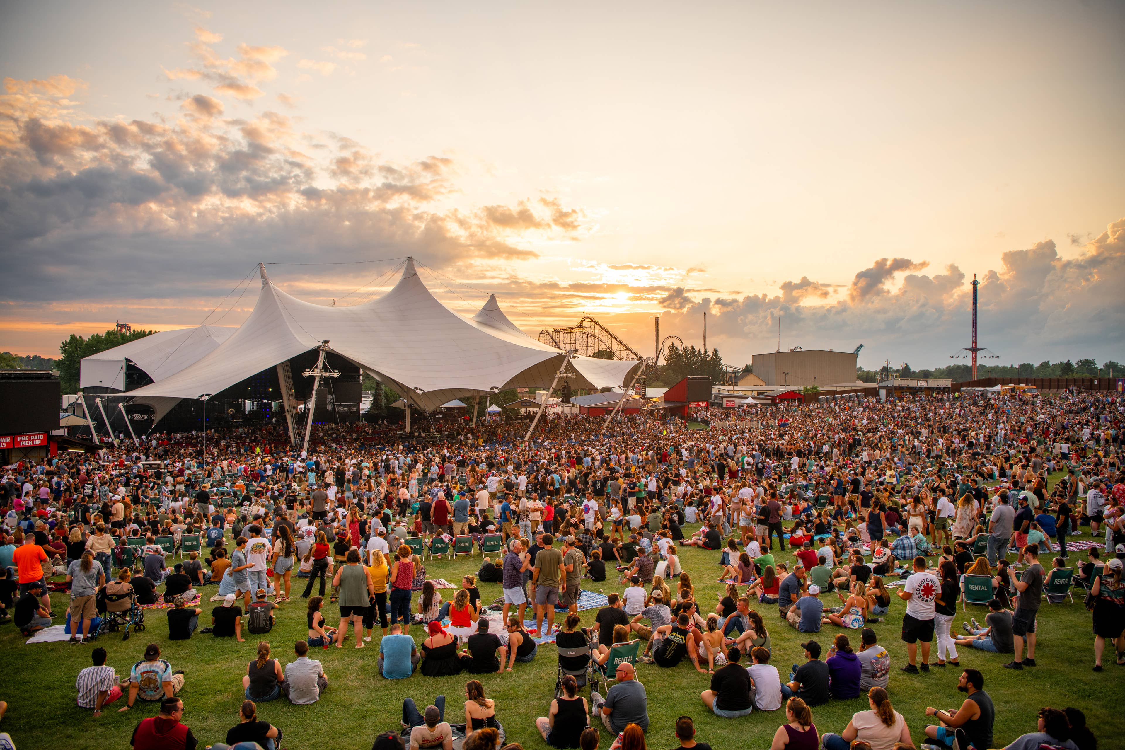 a photo of the lawn at sunset with a sold out crowd