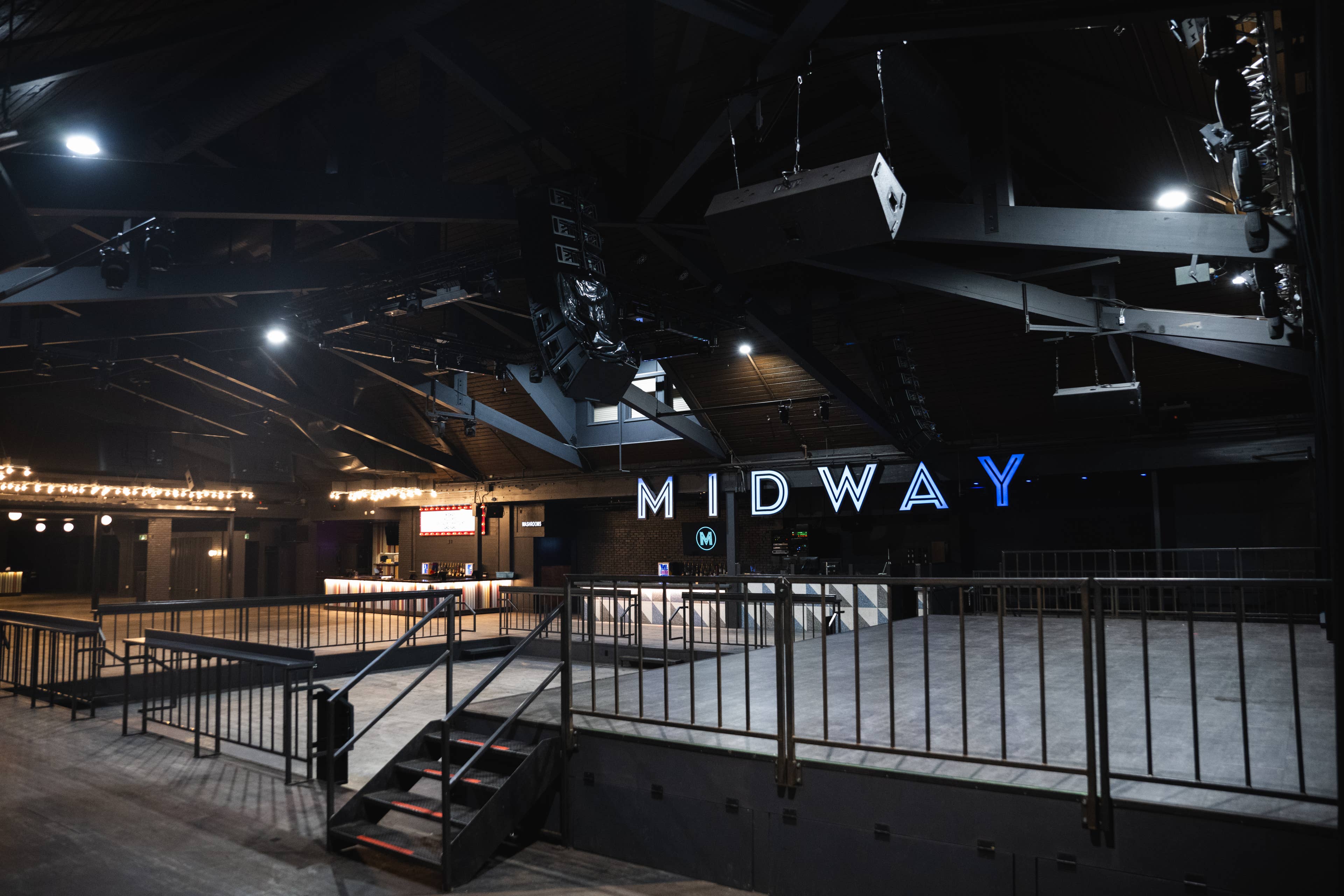 view of  midway music hall from behind the stage with an empty venue and their marquee sign visible