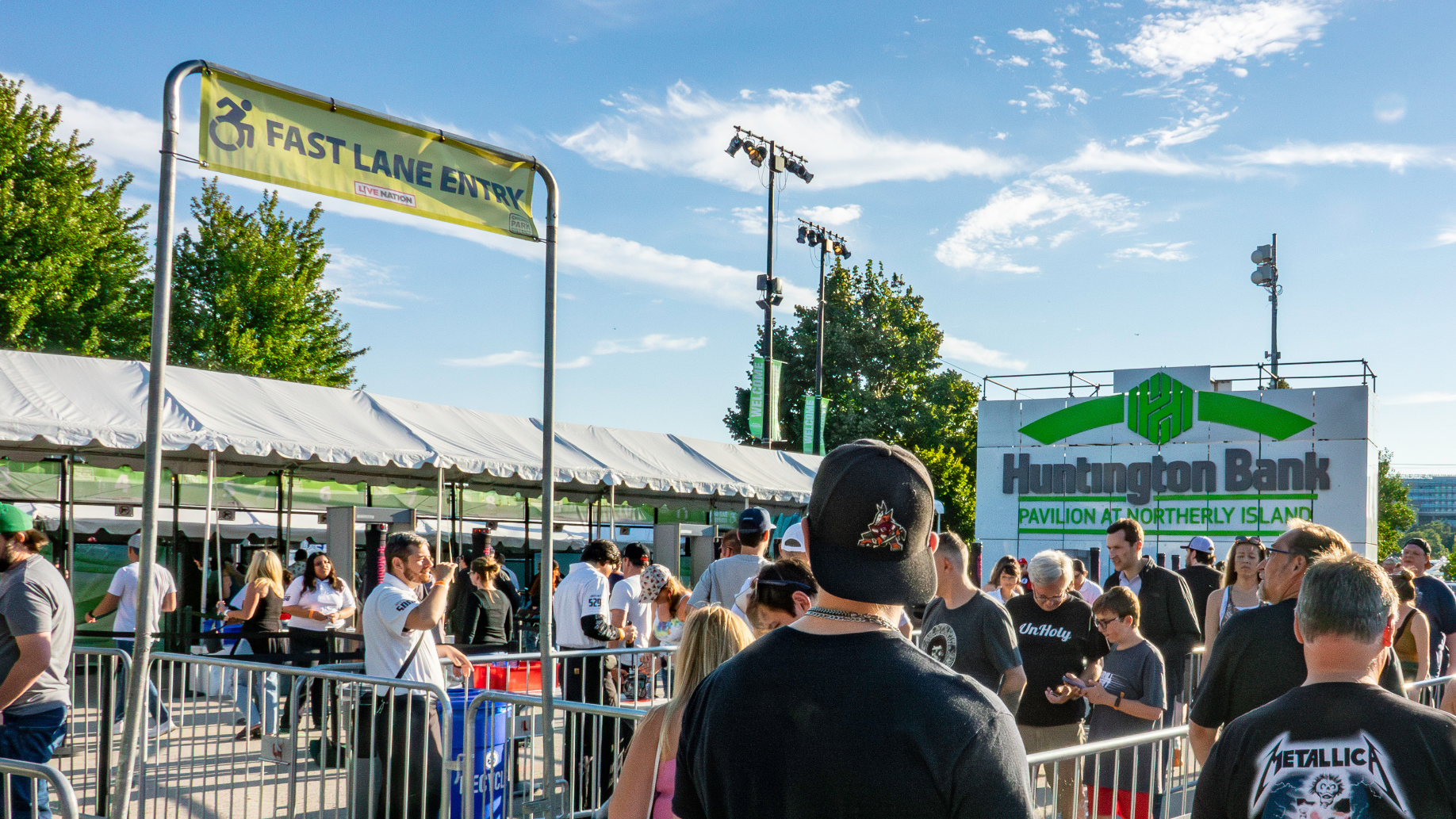 Fans outside the venue waiting in a general admission line to get inside, while the Fast Lane Entry next to them is empty. 