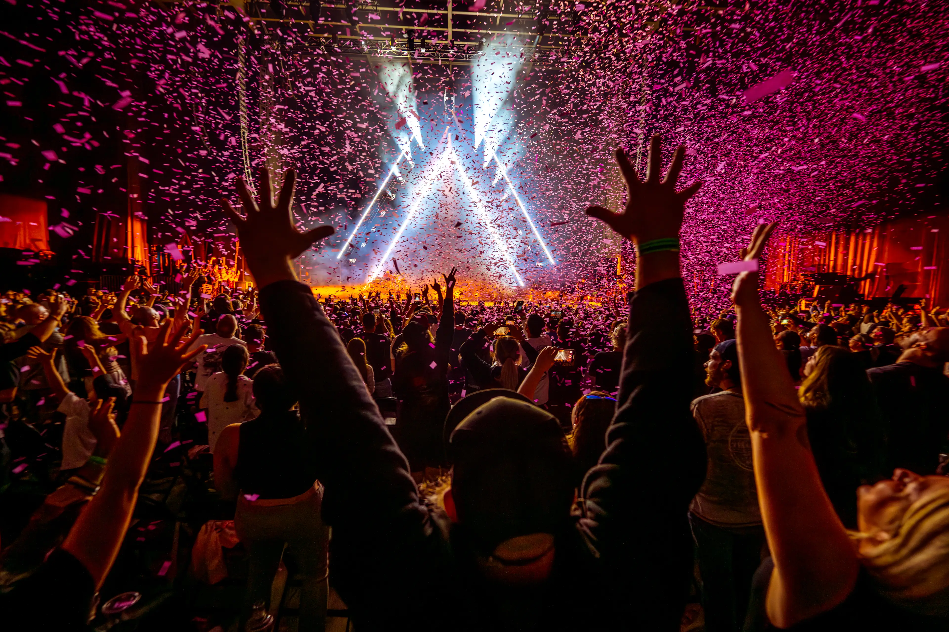 Photo of a fan with his hands up with confetti