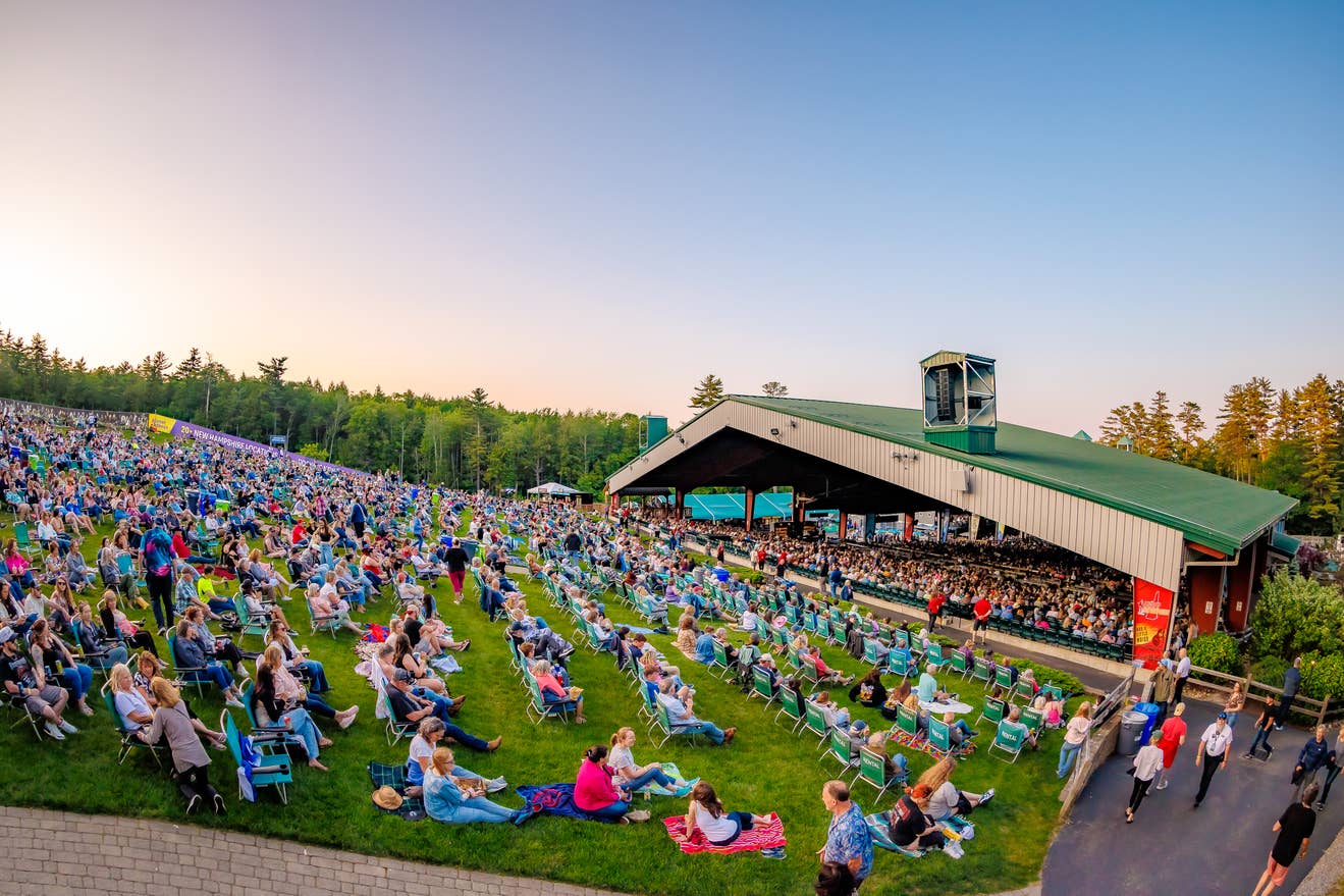 the lawn and pavilion full of fans at sunset