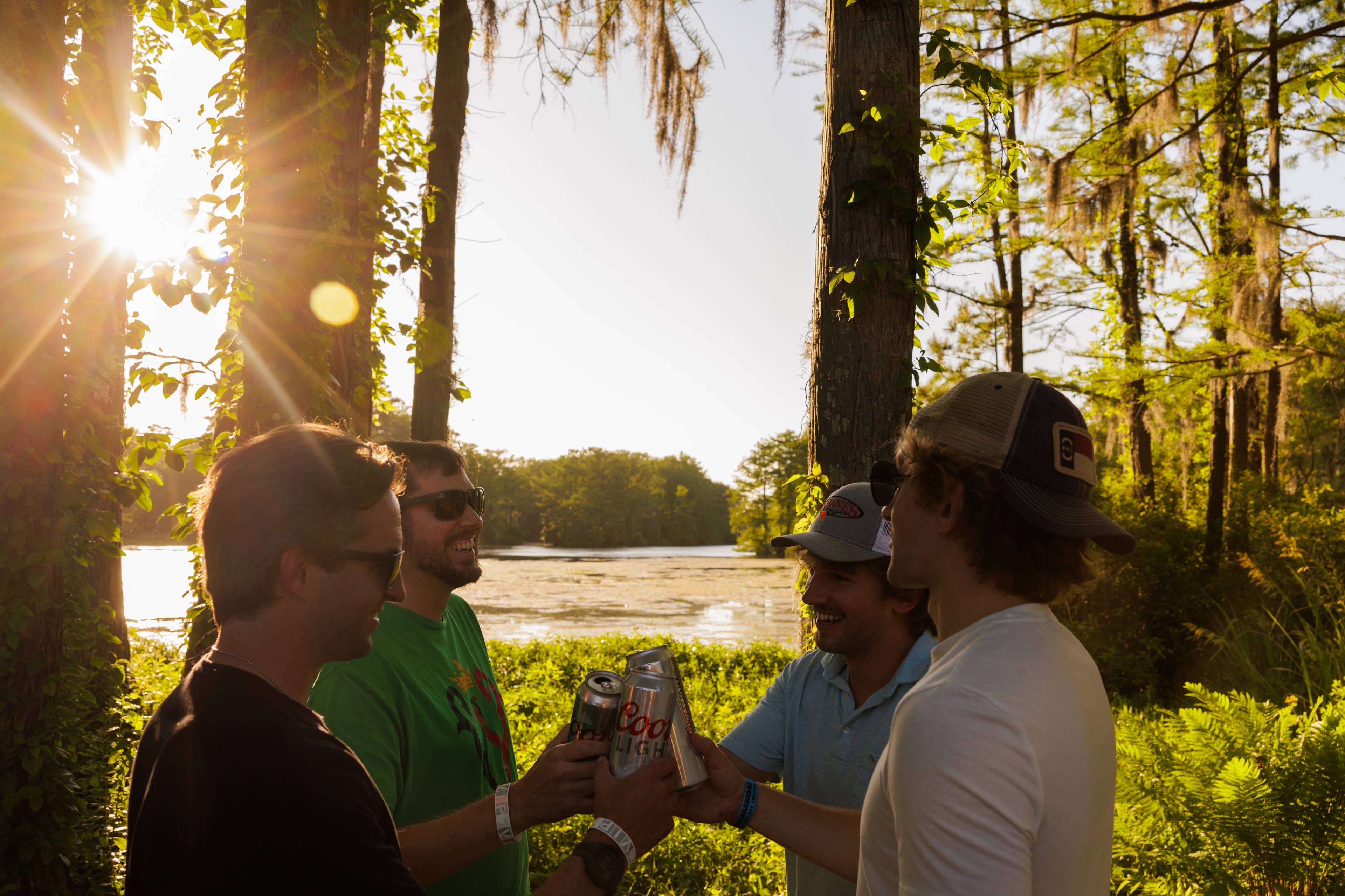 A group of friends clicking their drinks during sunset by Greenfield Lake.