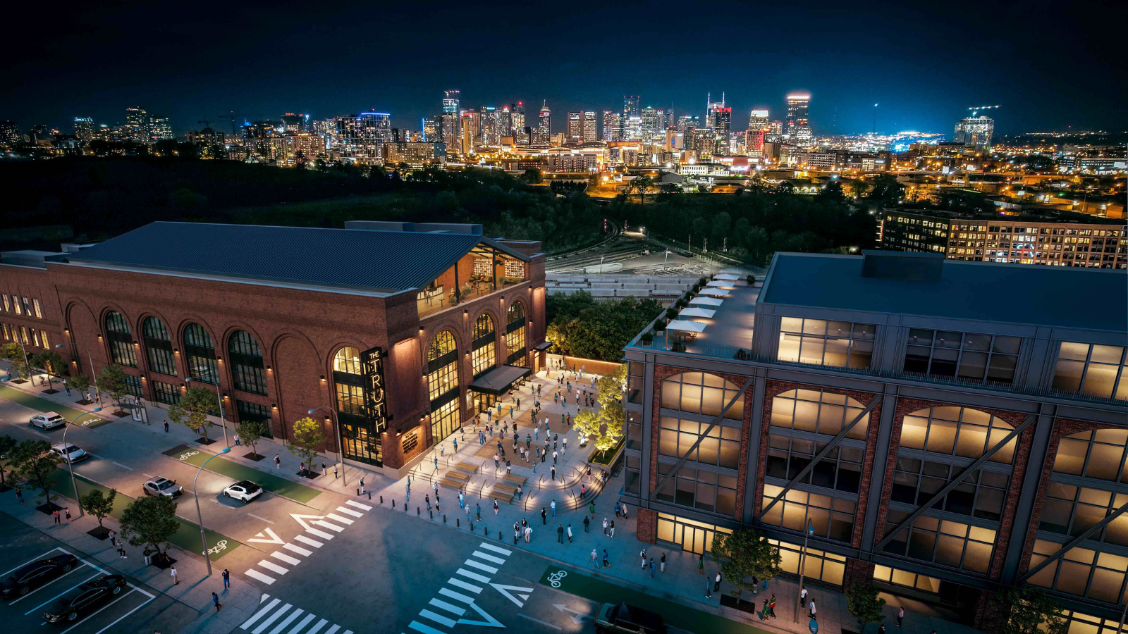 An aerial view of the exterior building of the venue and the city skyline