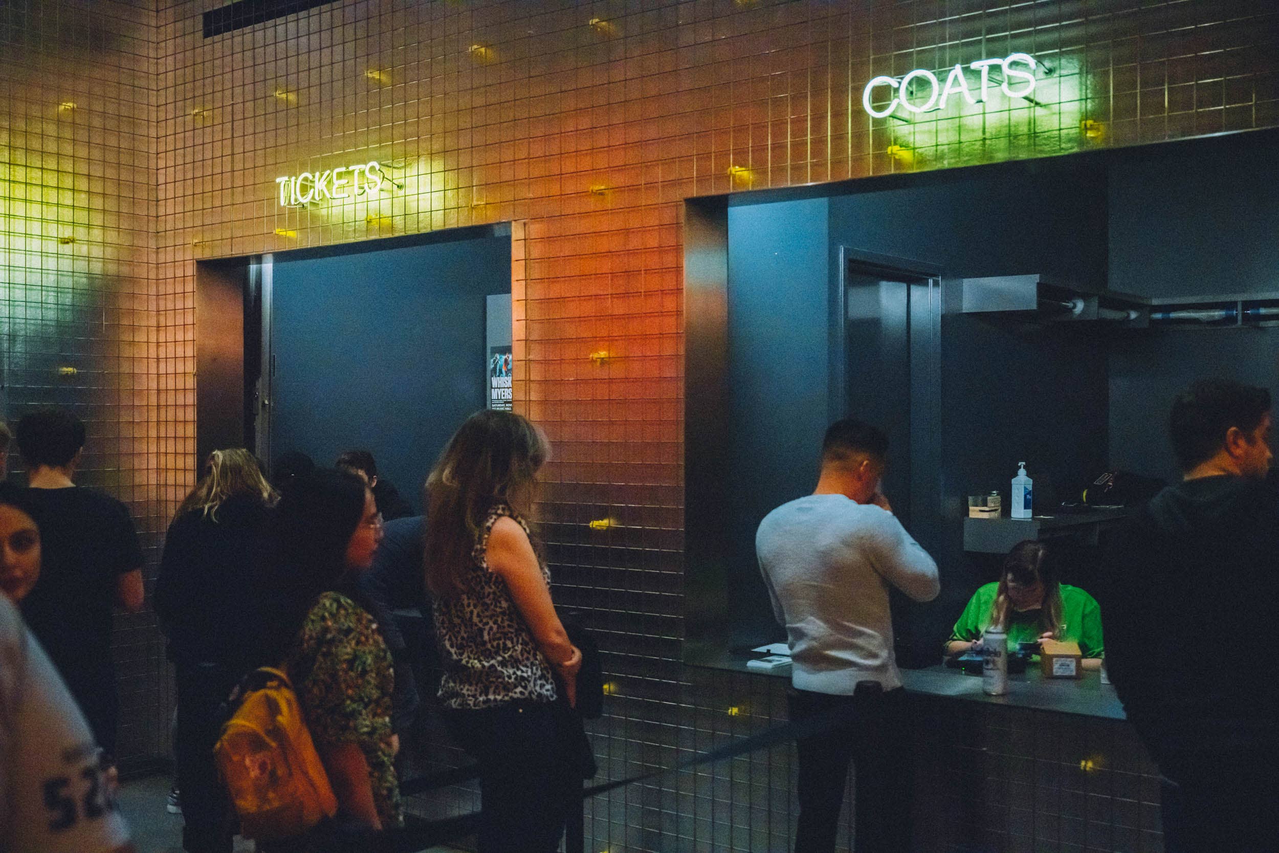 A line of people at the coat check area