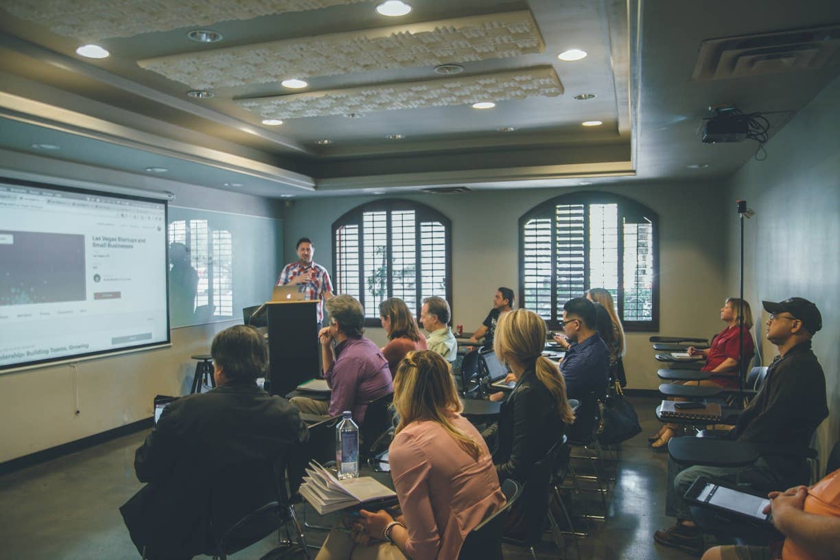 A teacher speaking to the students in a classroom.