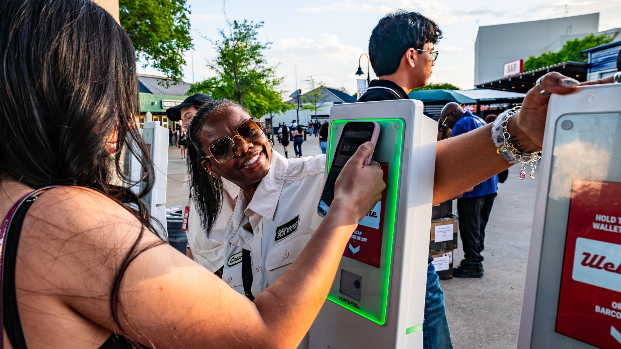 An employee helps a fan scan her ticket into the show at the venue entrance.