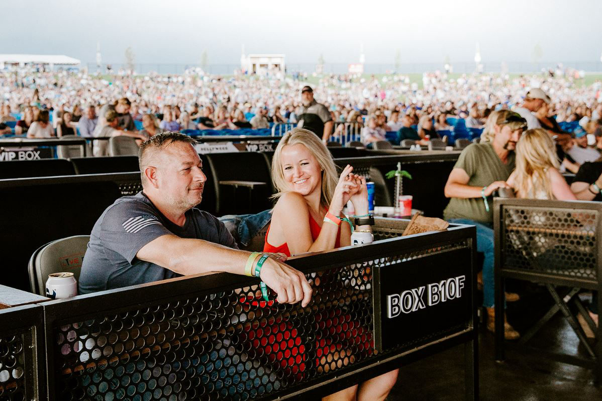 Fans smile as they enjoy a concert from box seats