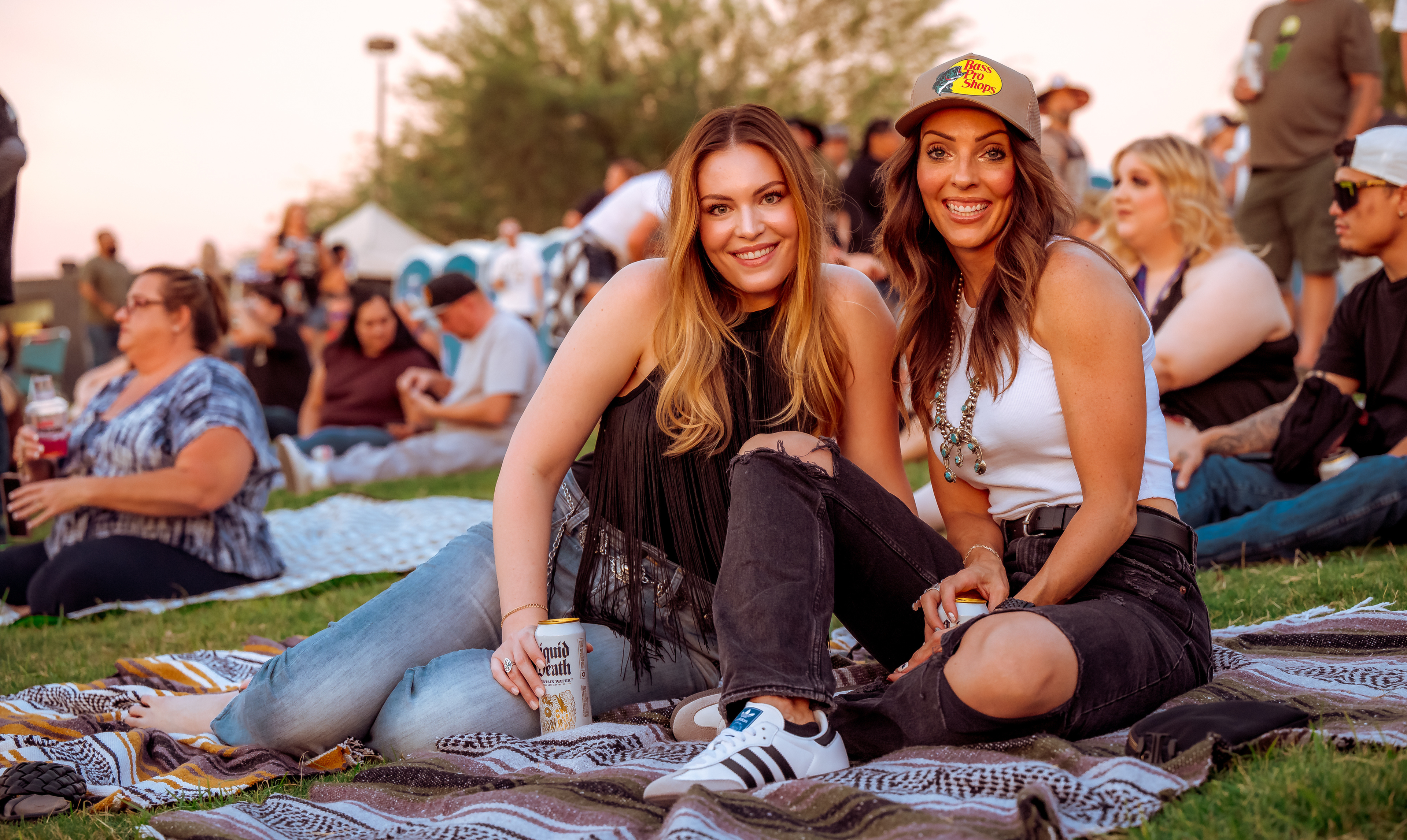 Two people, sitting on a blanket offered by the venue, smiling.