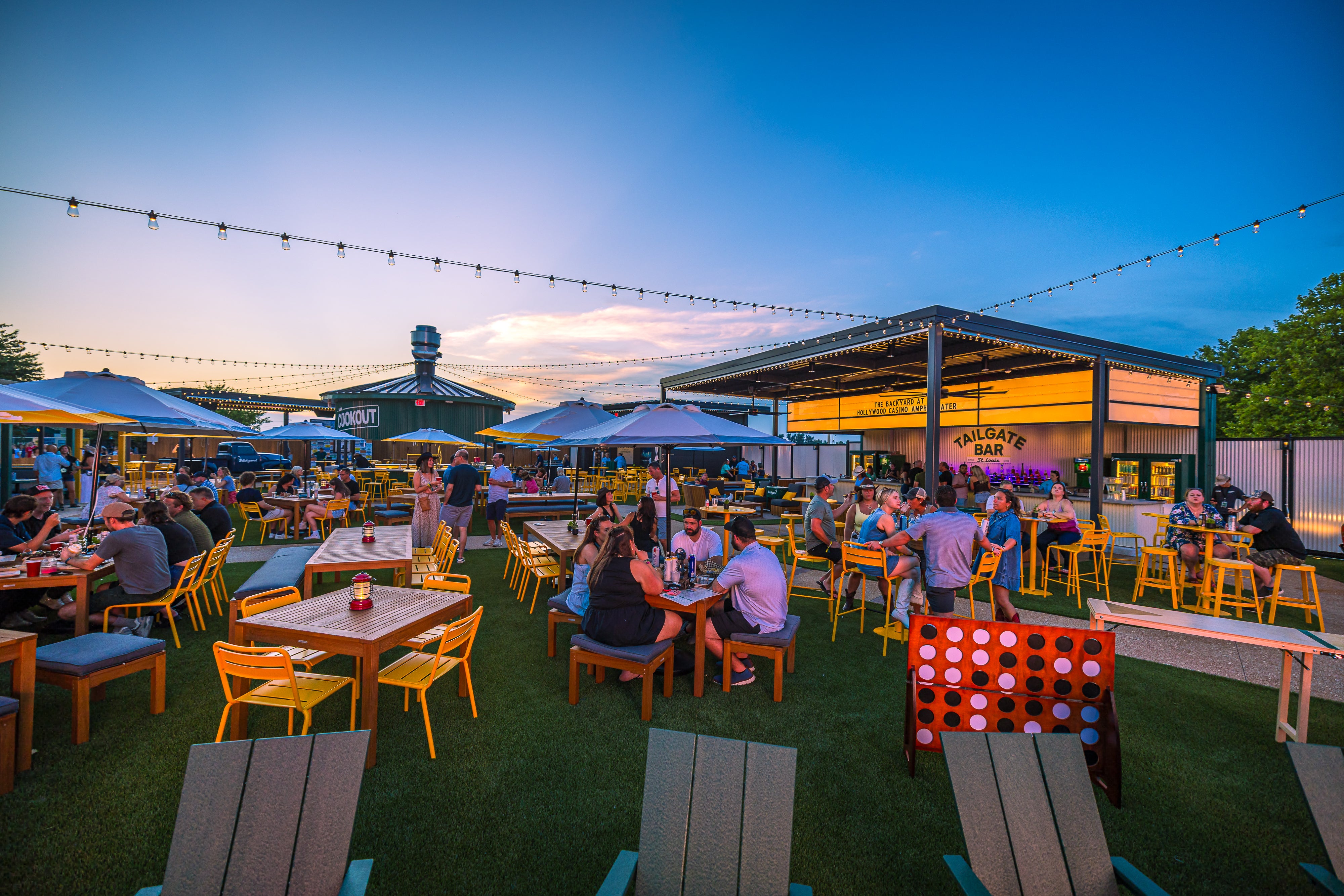 People gather at tables in the Backyard at Hollywood Casino Amphitheater.