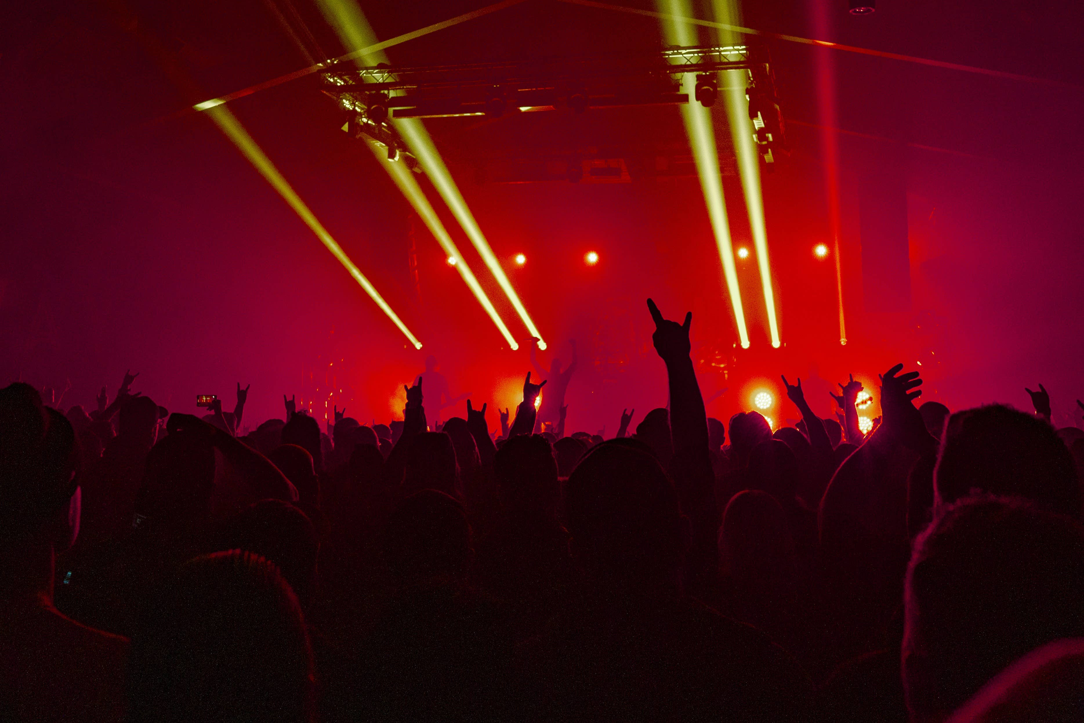 View of hands in the air and strobe lights at a concert at midway music hall