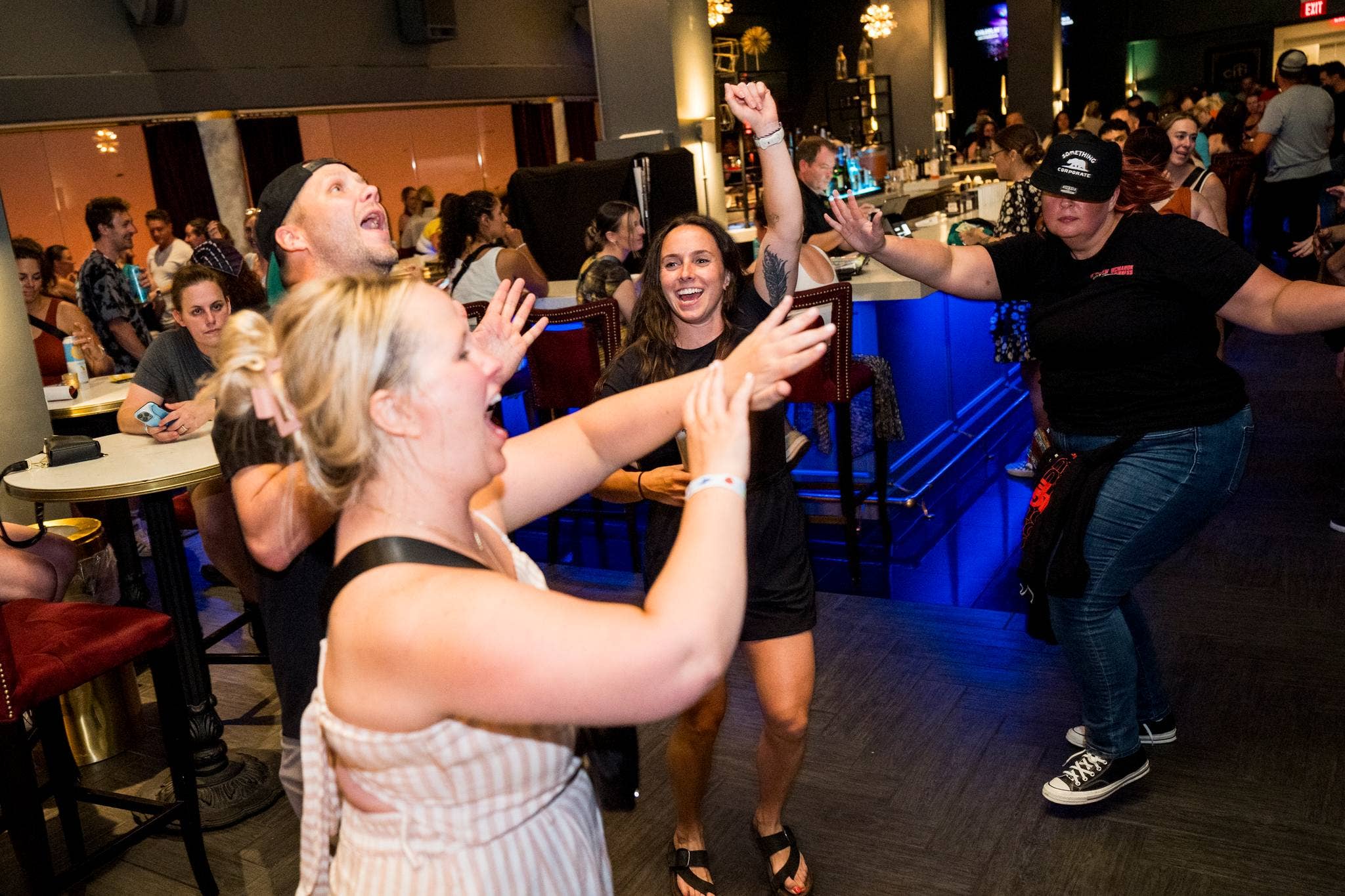 People dancing around near a bar