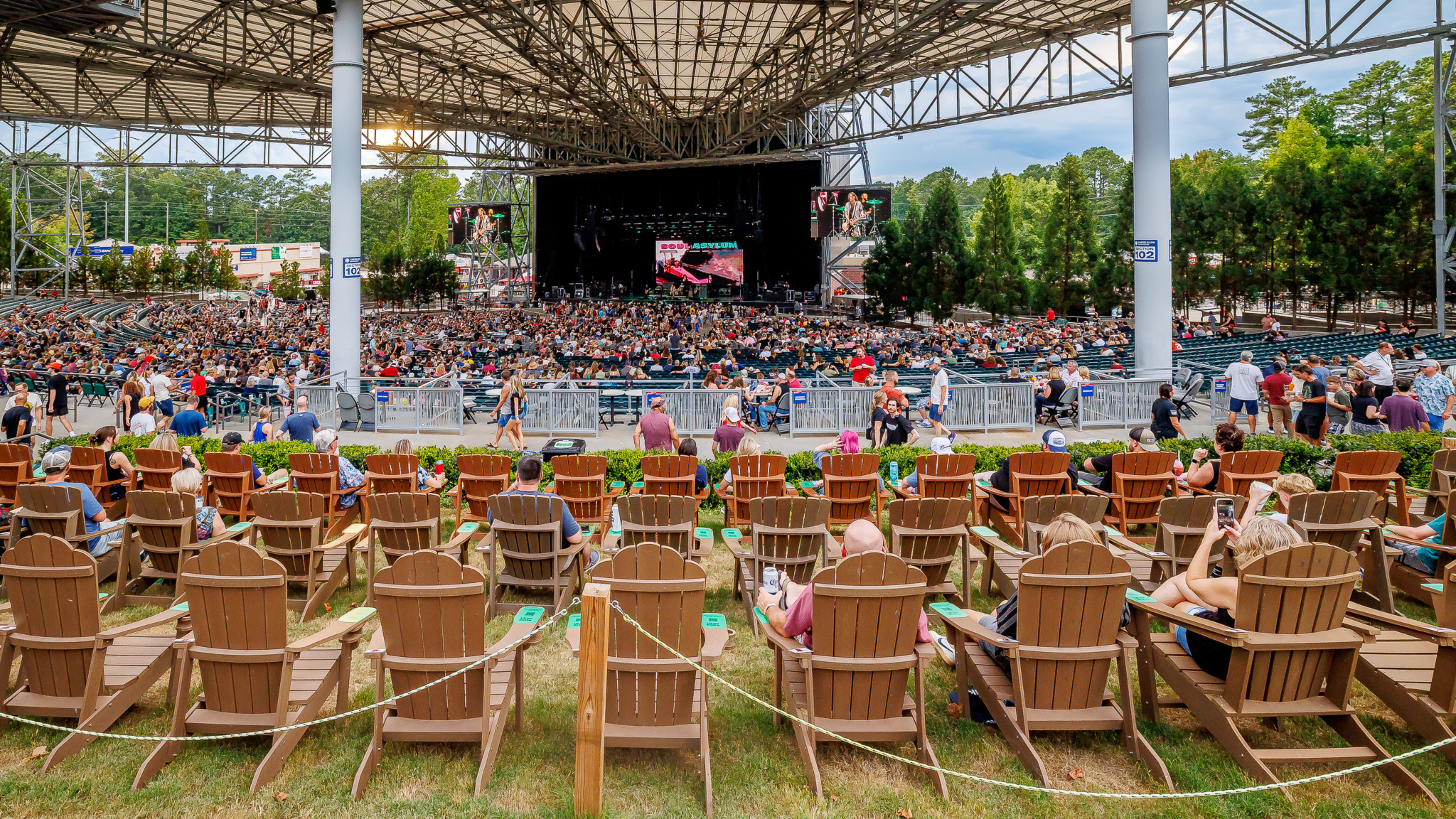 Three rows of Adirondack chairs roped off at the front of the lawn, facing the concert stage.