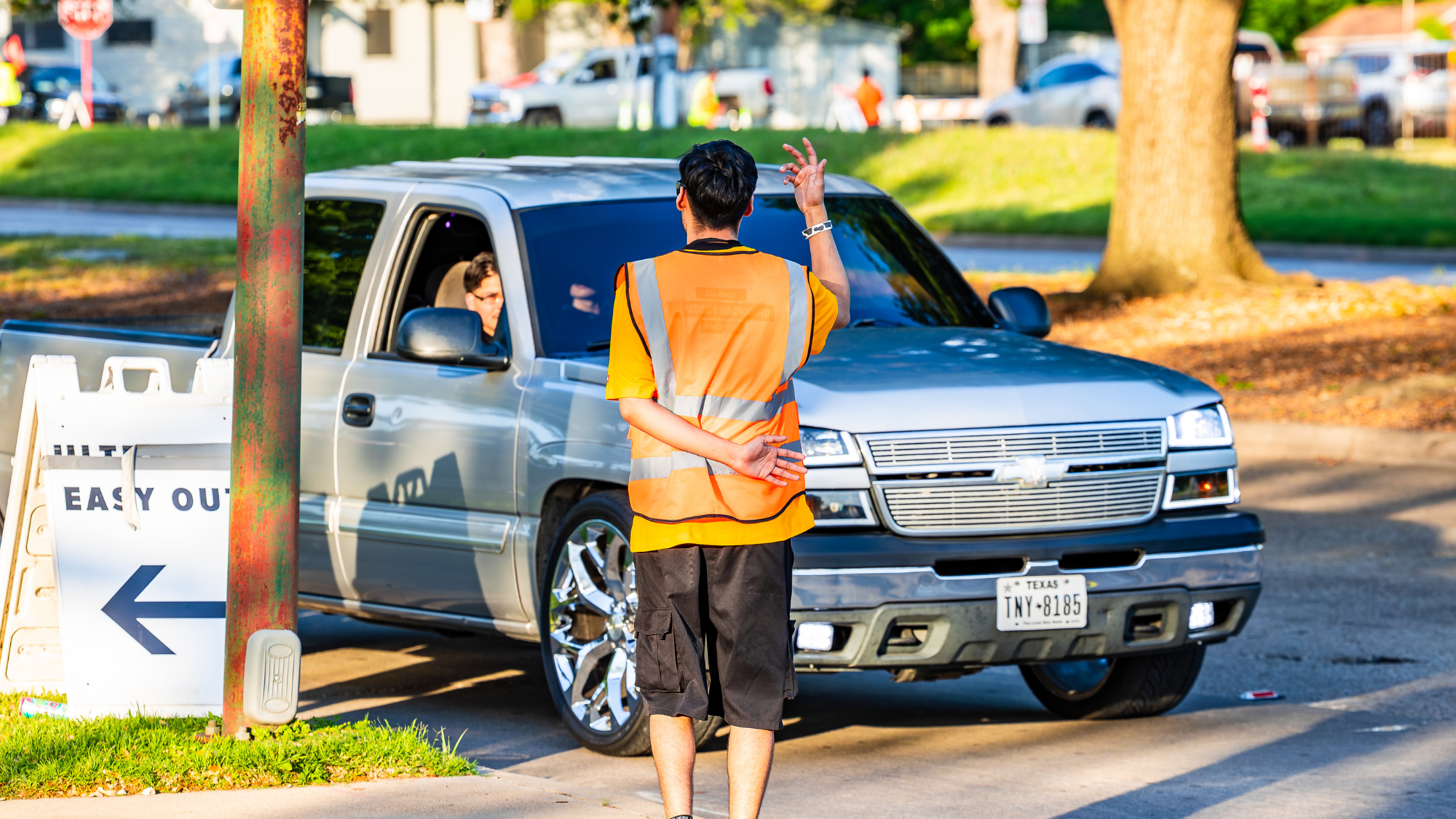 An employee directs a truck into a parking lot.