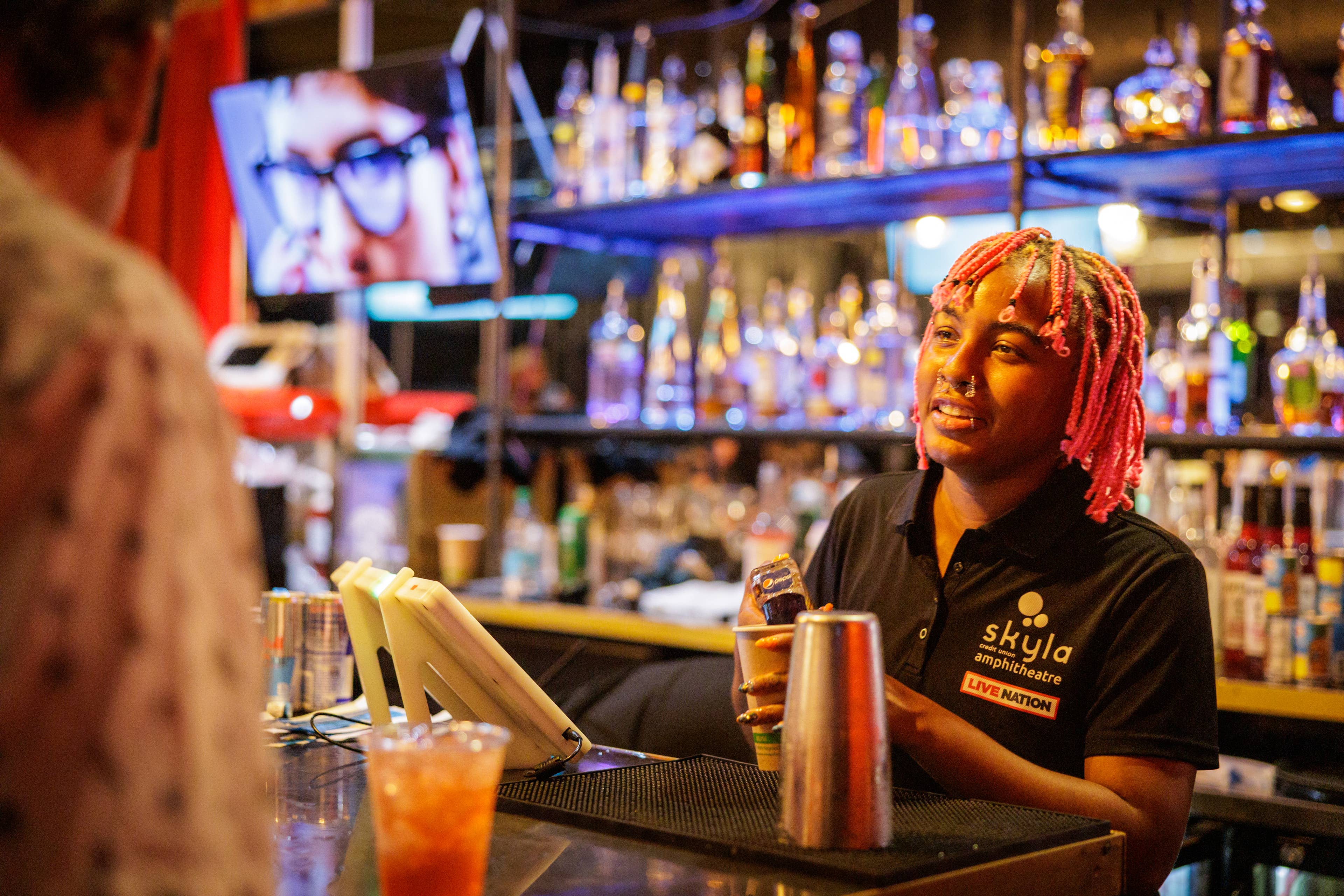 A women bartender serving drinks in the VIP Club at Skyla Credit Union Amphitheatre.