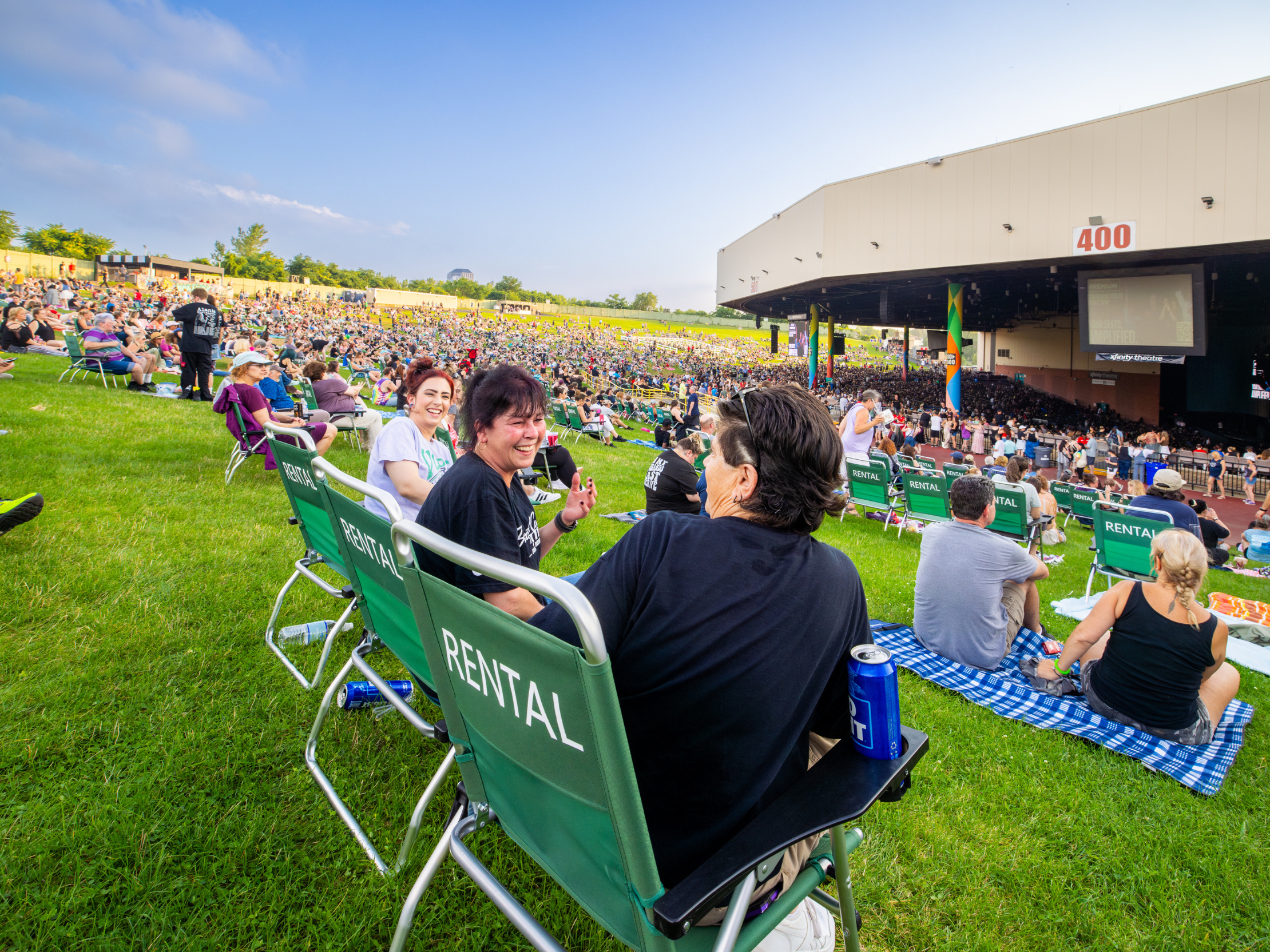 a group of people sitting in green lawn chairs, smiling and laughing