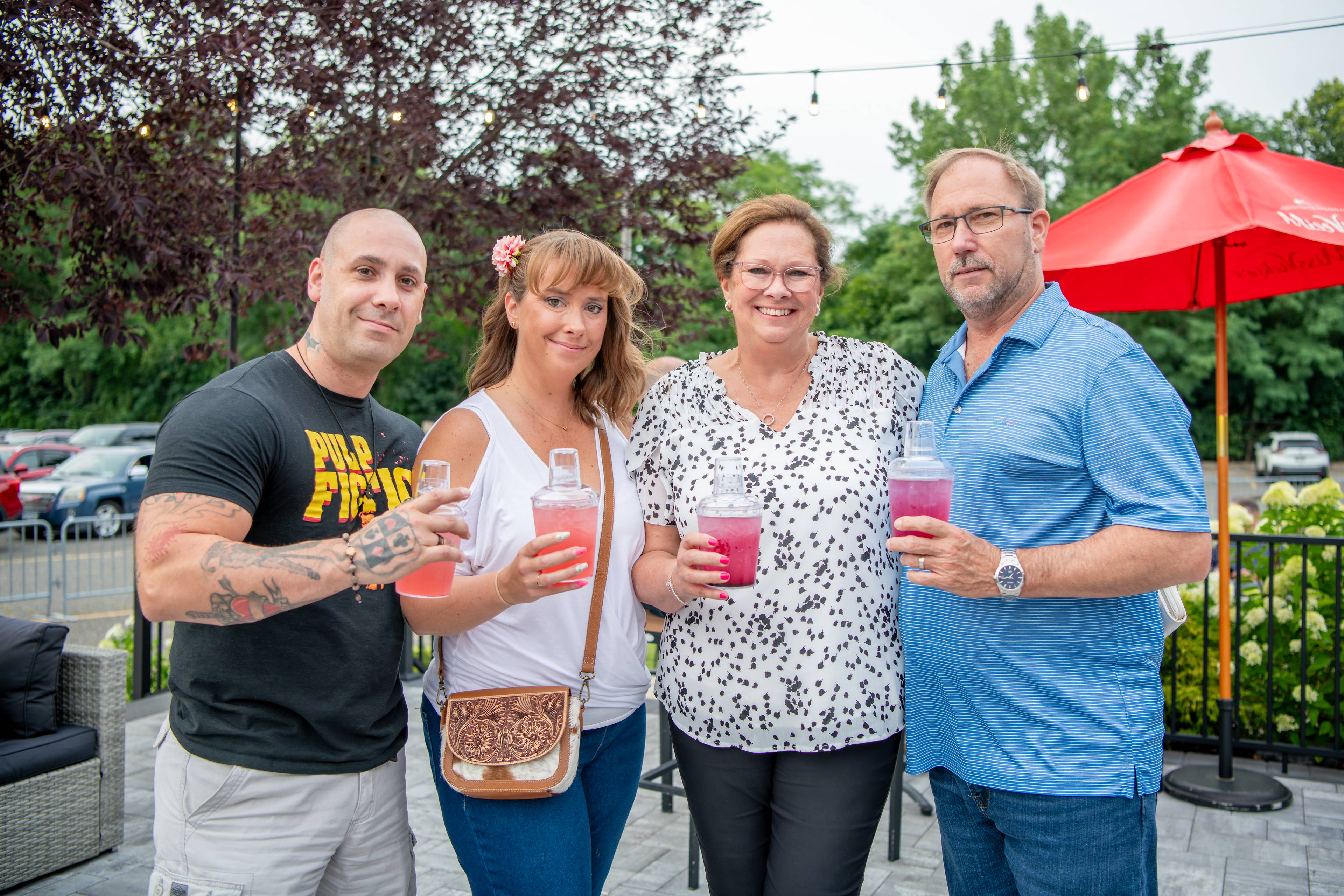 Four people holding the shaker cups and facing the camera