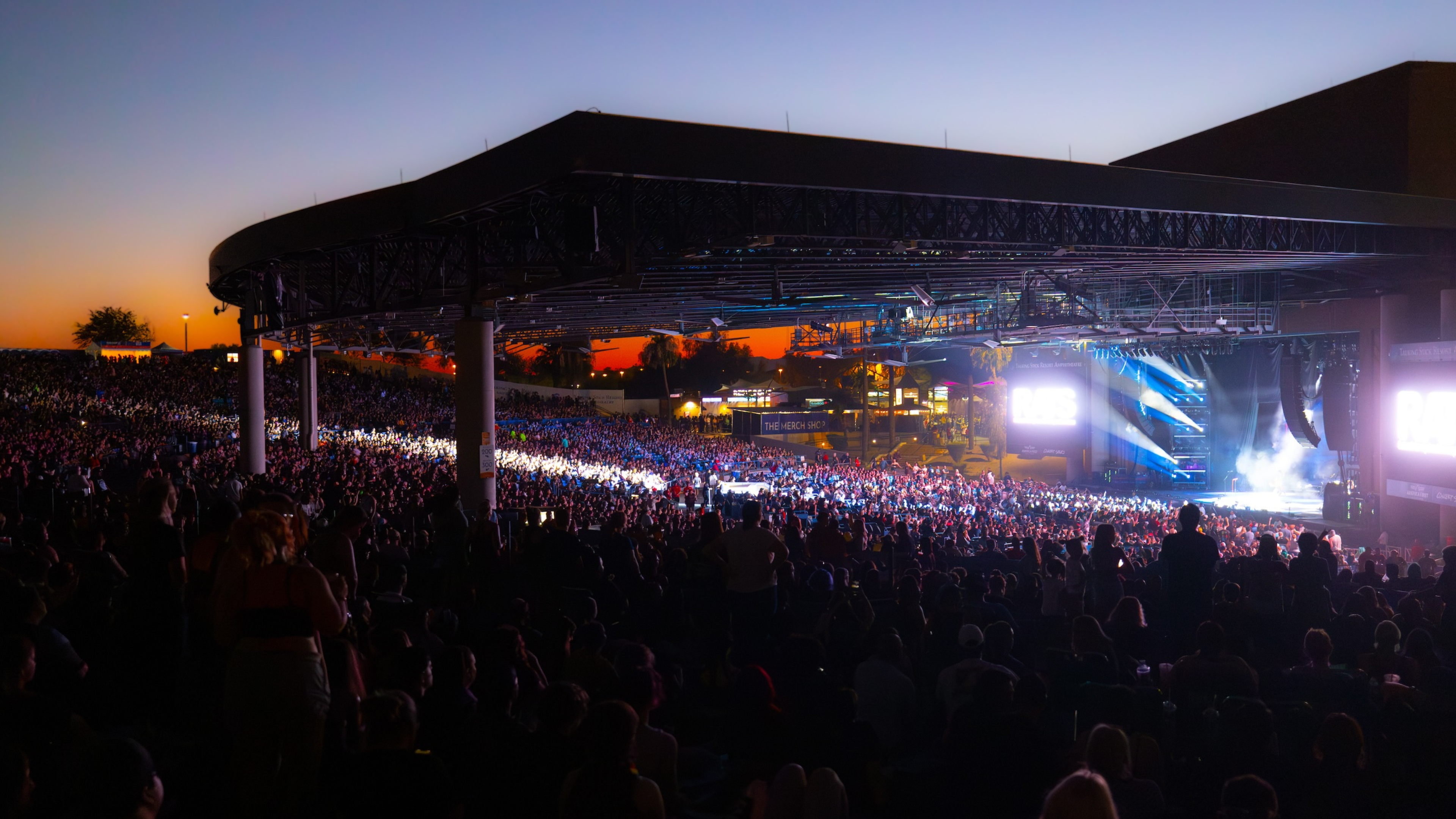 Side view of the venue with the stage and a crowd full of people