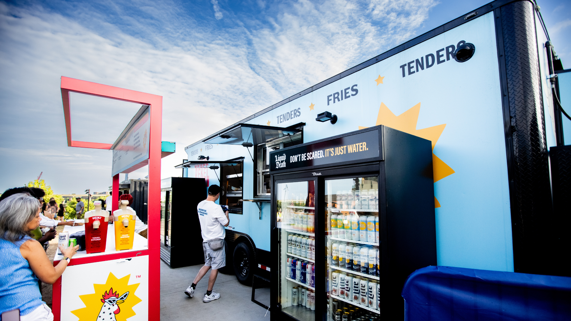 Large food truck serving chicken tenders and fries parked inside the venue.