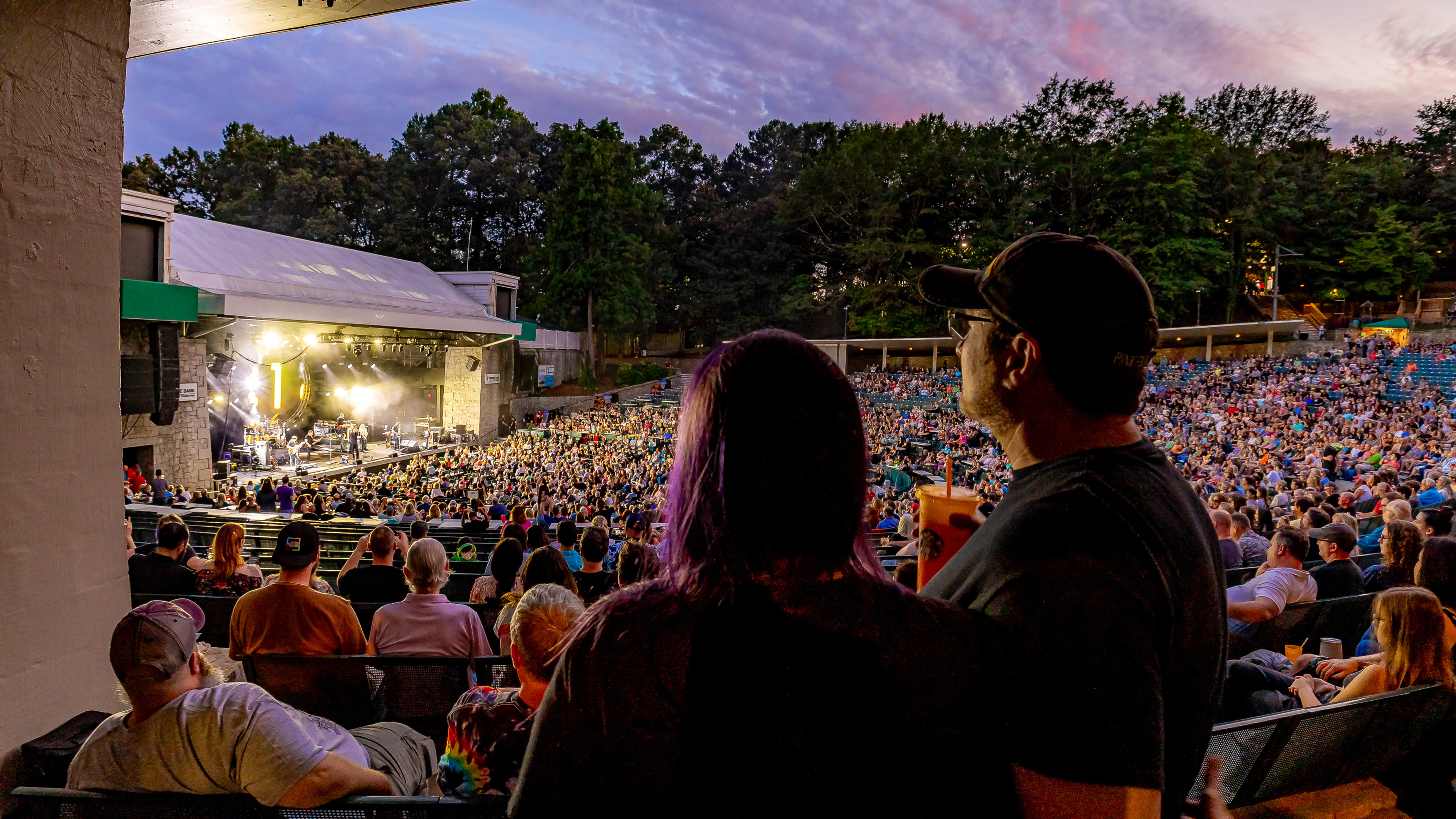 Two people watching a concert at Synovus Bank Amphitheater at Chastain Park.