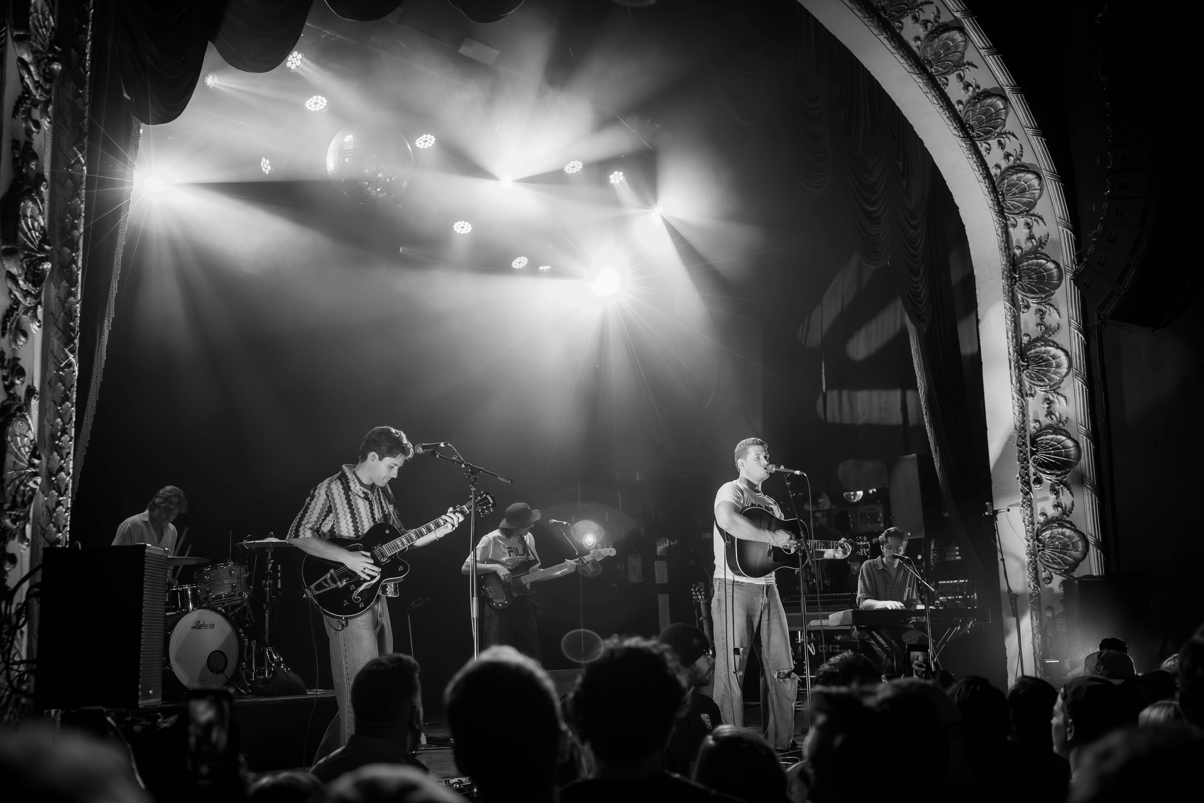 A band playing on stage in black and white