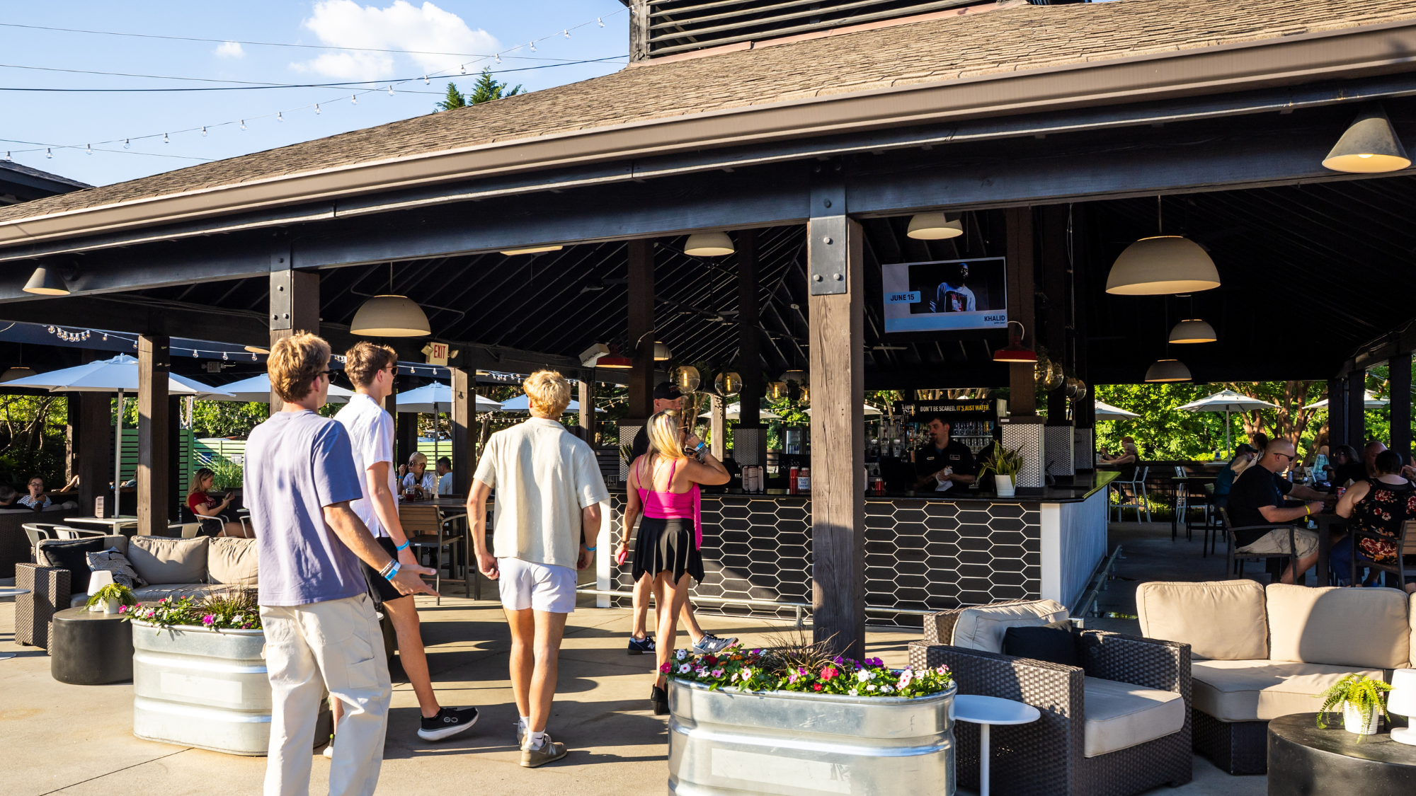 A group of fans walking into the VIP Club to order a drink at the private bar and sit in the covered lounge area.