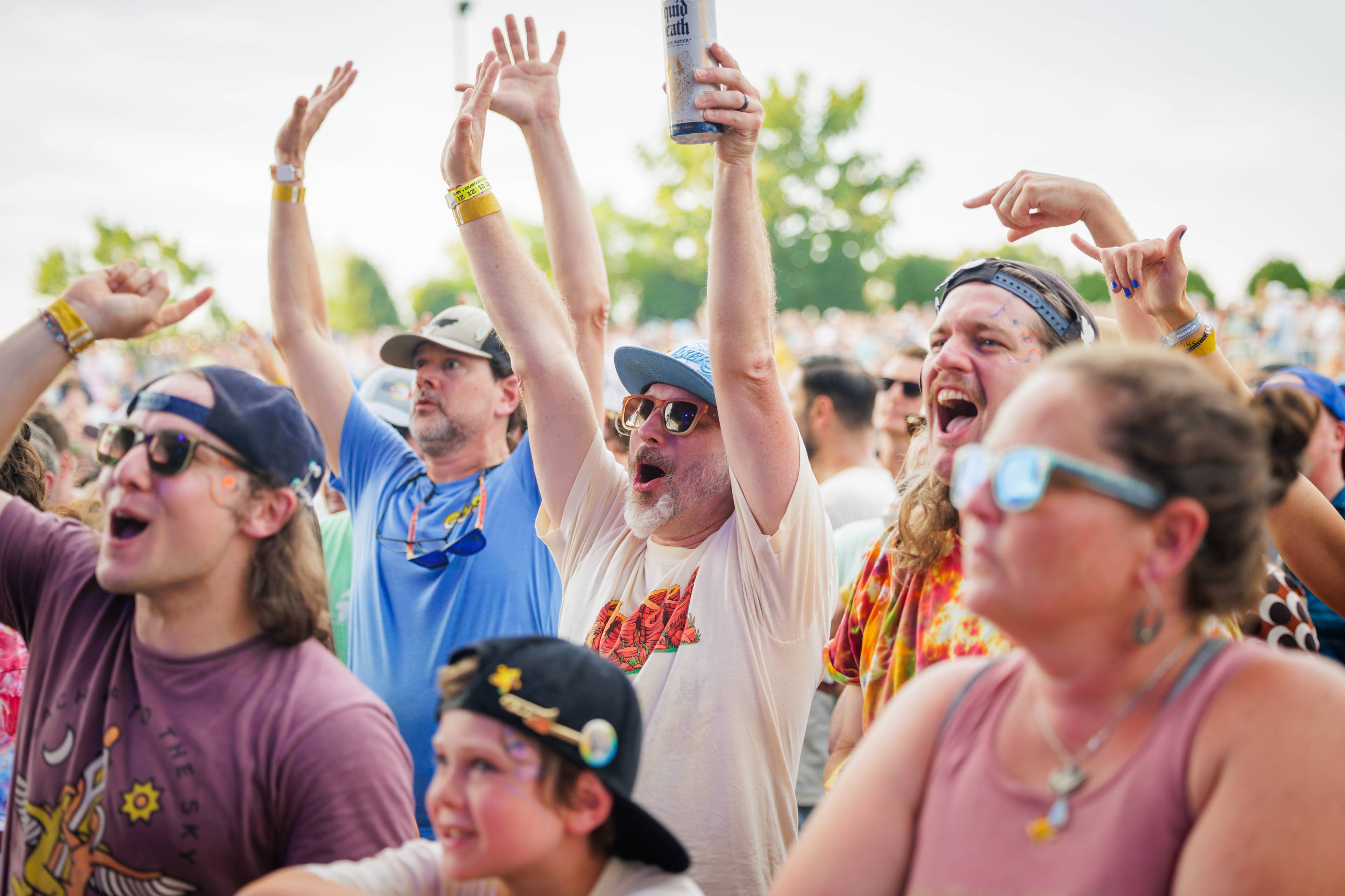Men in the pit smiling with their hands up and excited at the Goose show at Skyla Credit Union Amphitheatre.