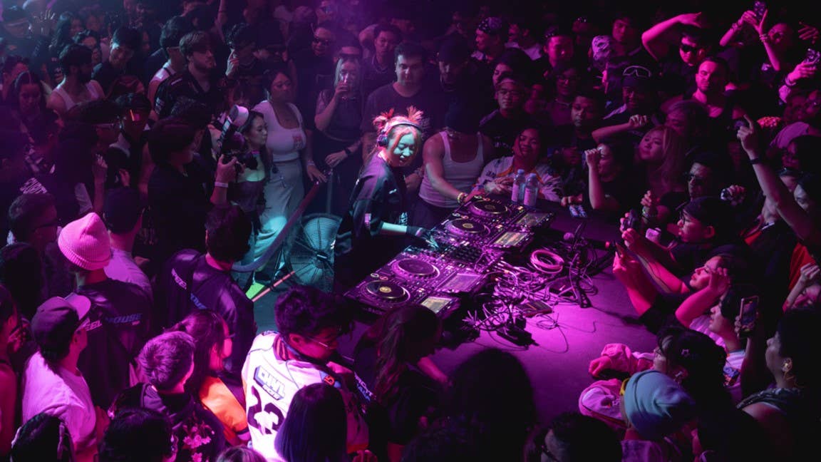 DJ in the center of the floor at The Mod Club in Toronto with a crowd surrounding her and pink lighting 