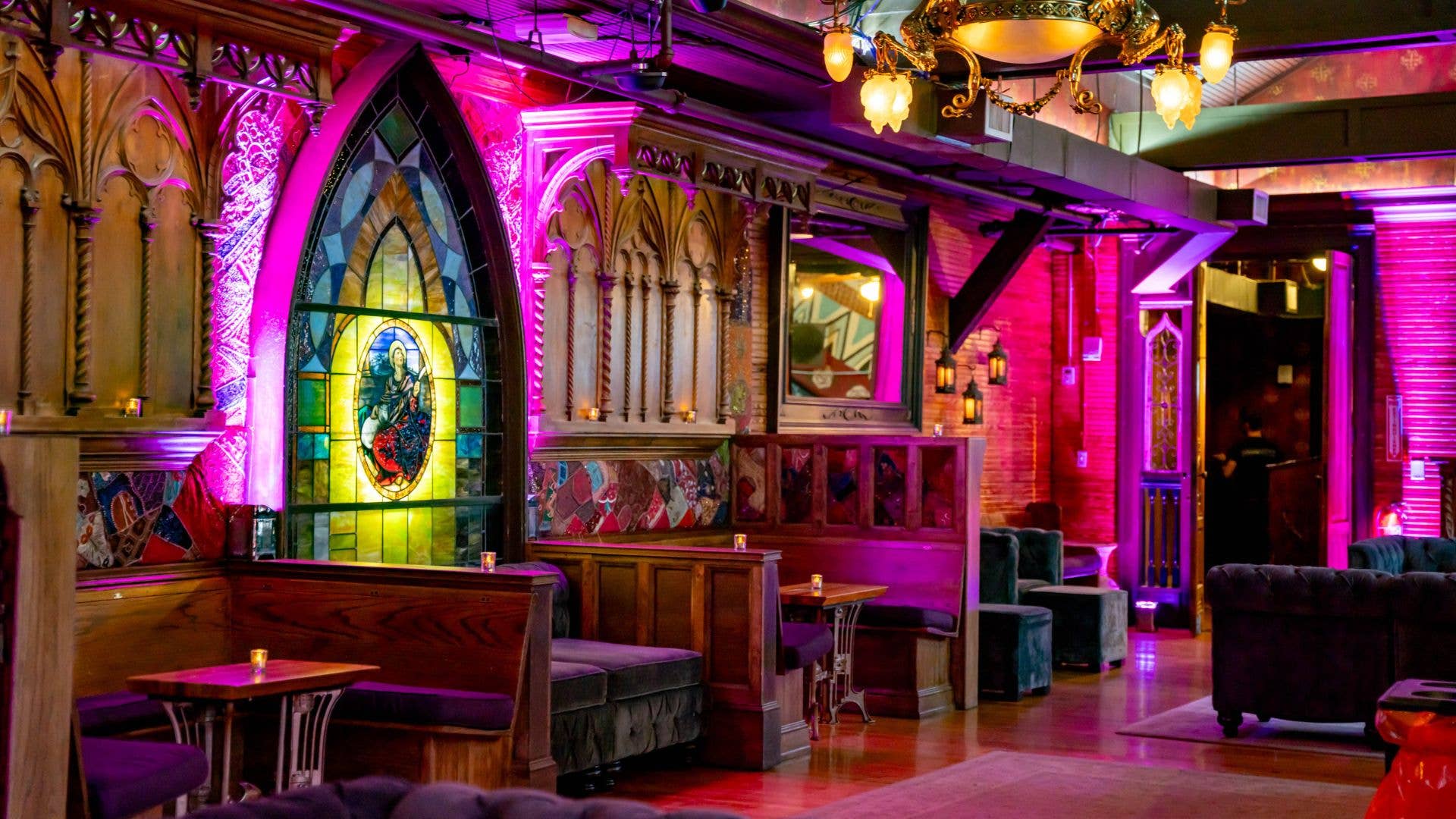 An image of the lounge with stained glass windows, couches, and booths