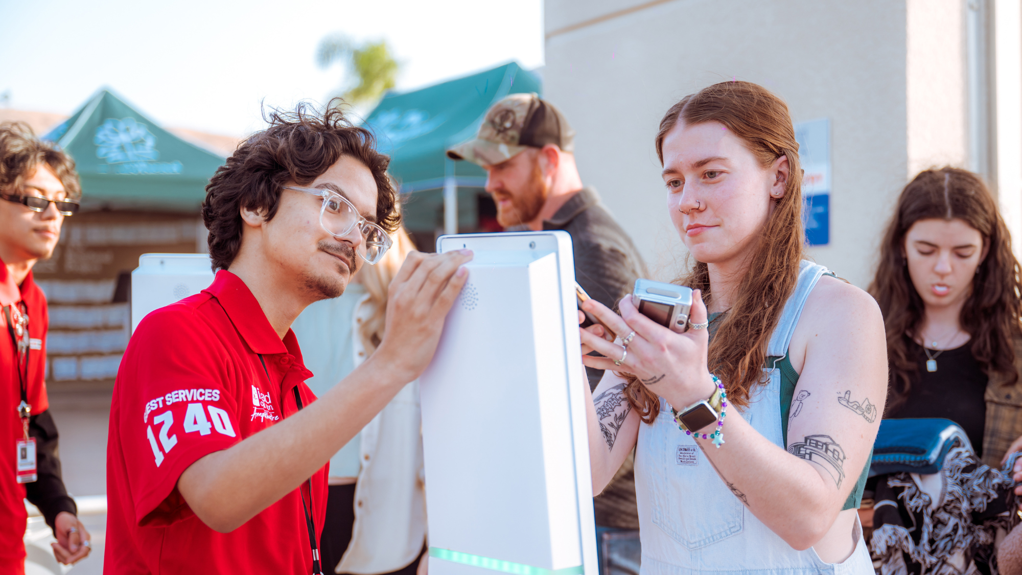 An employee helps a girl scan into the venue.