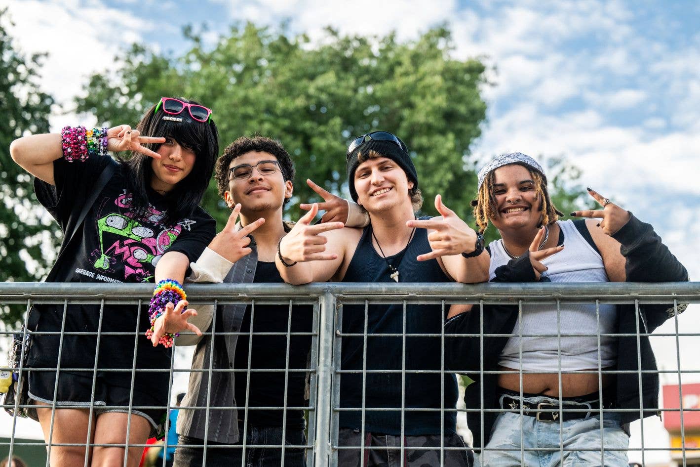 People are smiling and posing for the camera with trees in the background